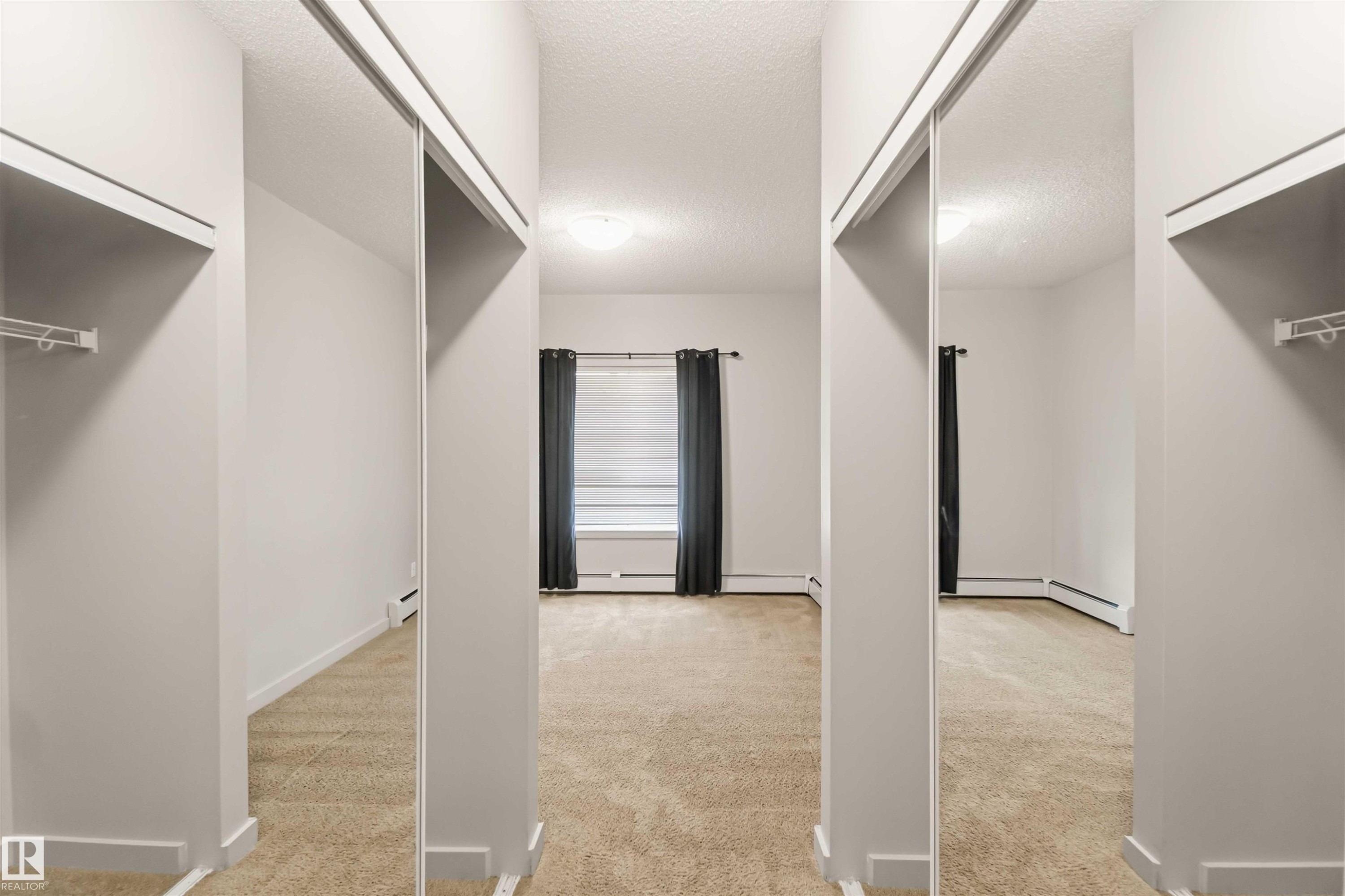 Wall-to-wall carpeting with mirrored closet doors - #414 5510 Schonsee Dr Nw, Edmonton, AB