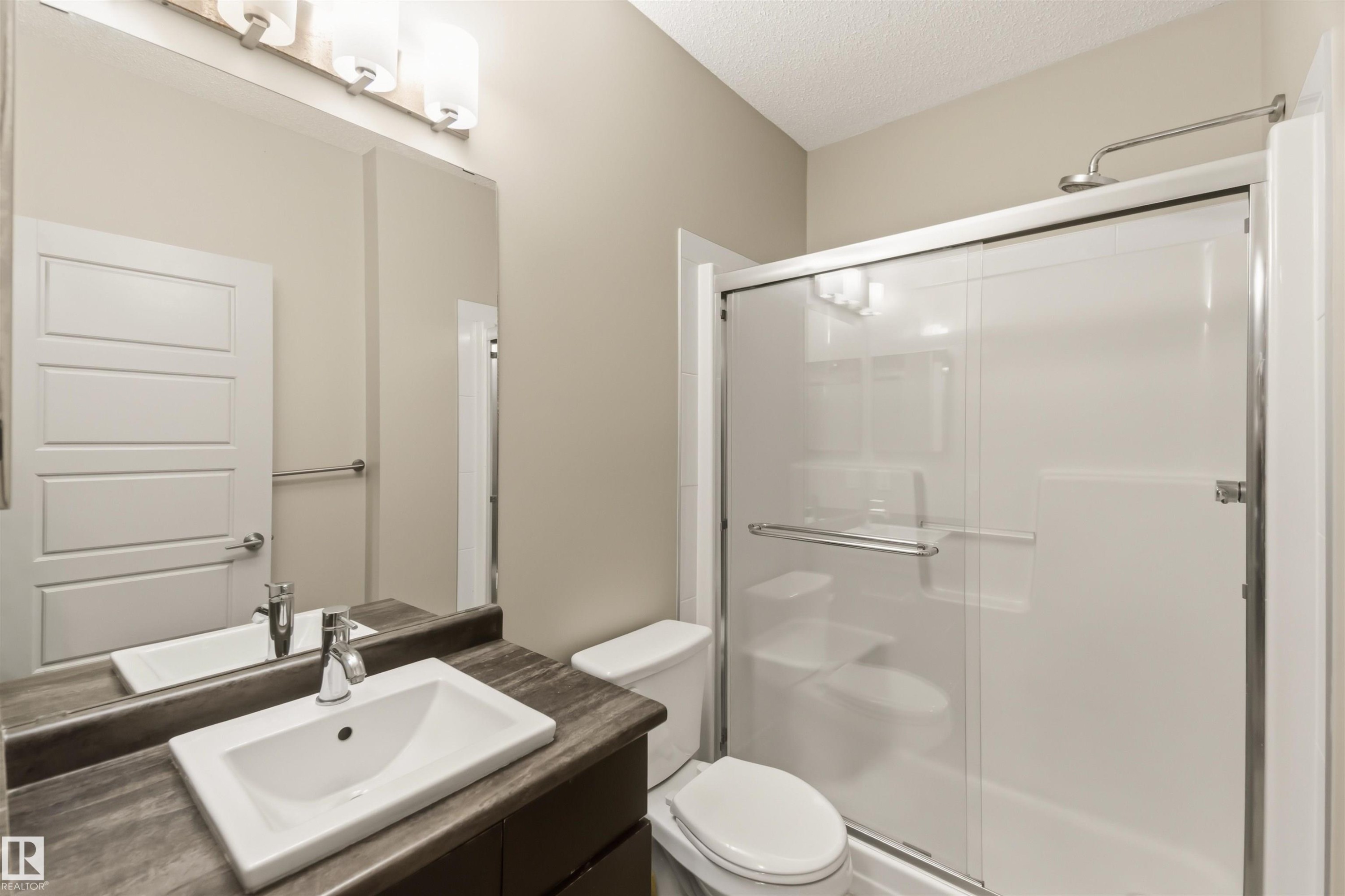 Integrated vanity with a rectangular basin sink, chrome faucet, and storage cabinetry - #414 5510 Schonsee Dr Nw, Edmonton, AB