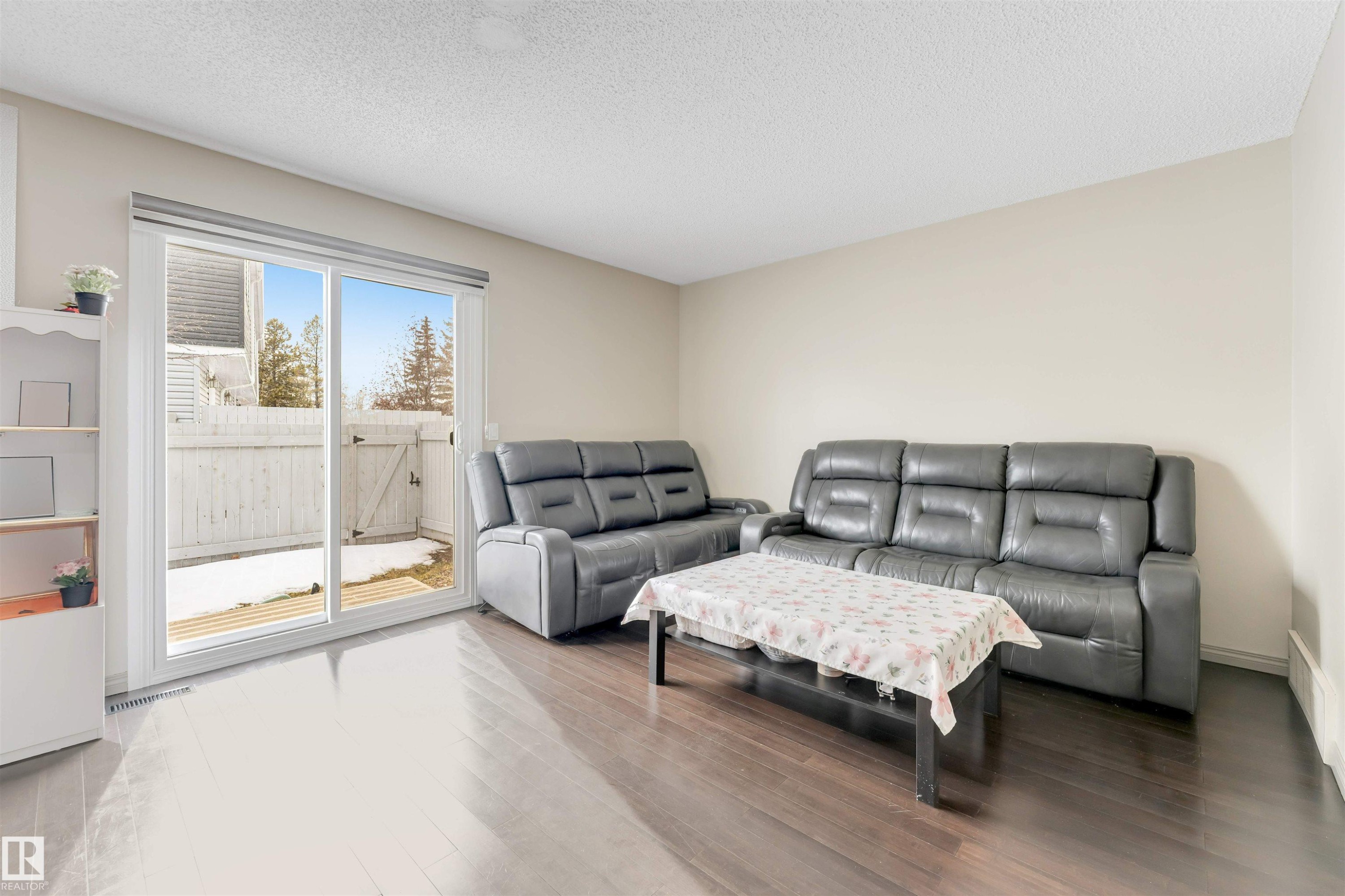 Wood-finish flooring, light-toned walls, and a sliding glass patio door - #37 1411 Mill Woods Rd E Nw, Edmonton, AB - Indoor Photo Showing Living Room