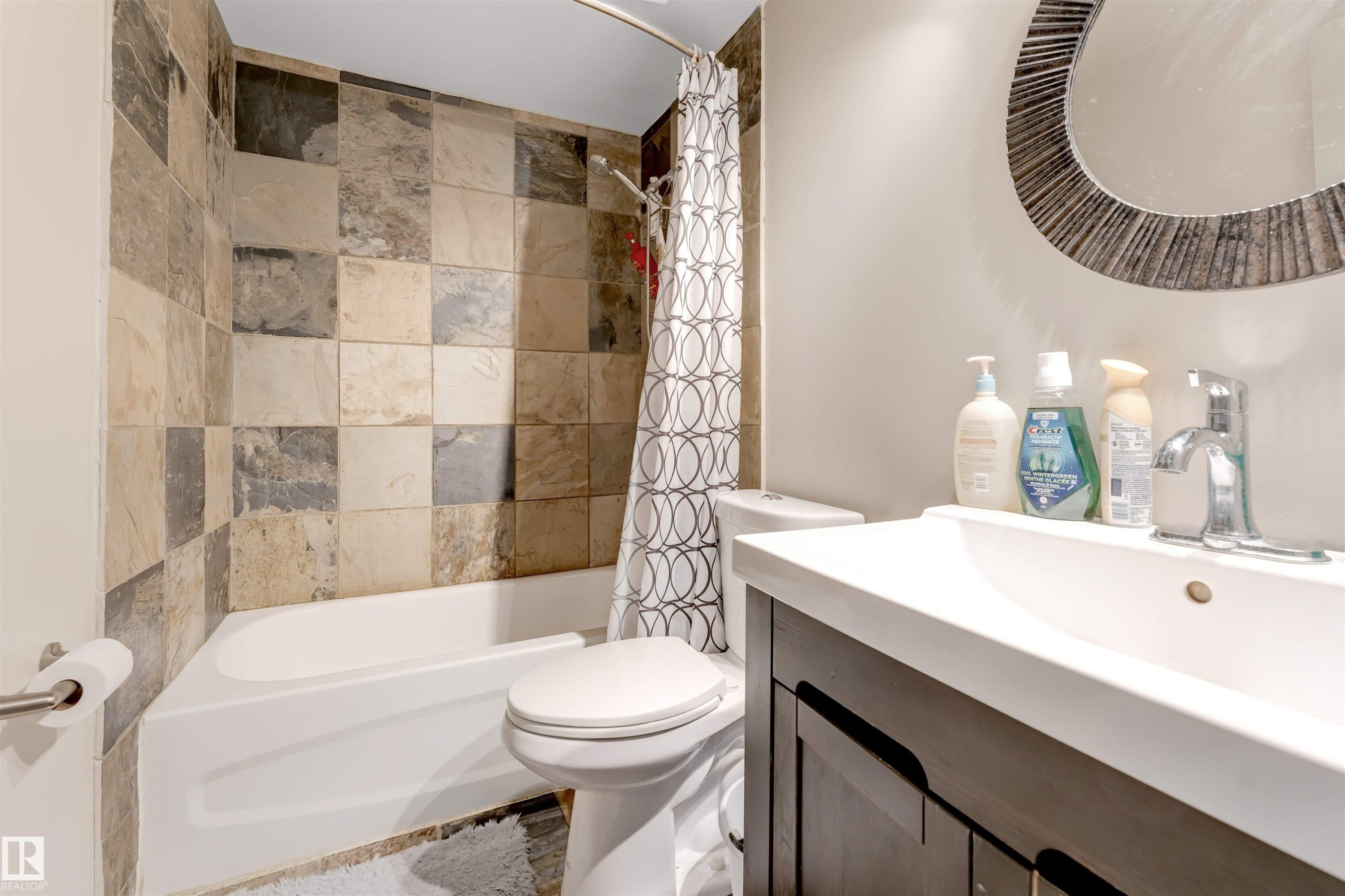 White drop-in bathtub with a mixed-tone tiled surround - #37 1411 Mill Woods Rd E Nw, Edmonton, AB - Indoor Photo Showing Bathroom