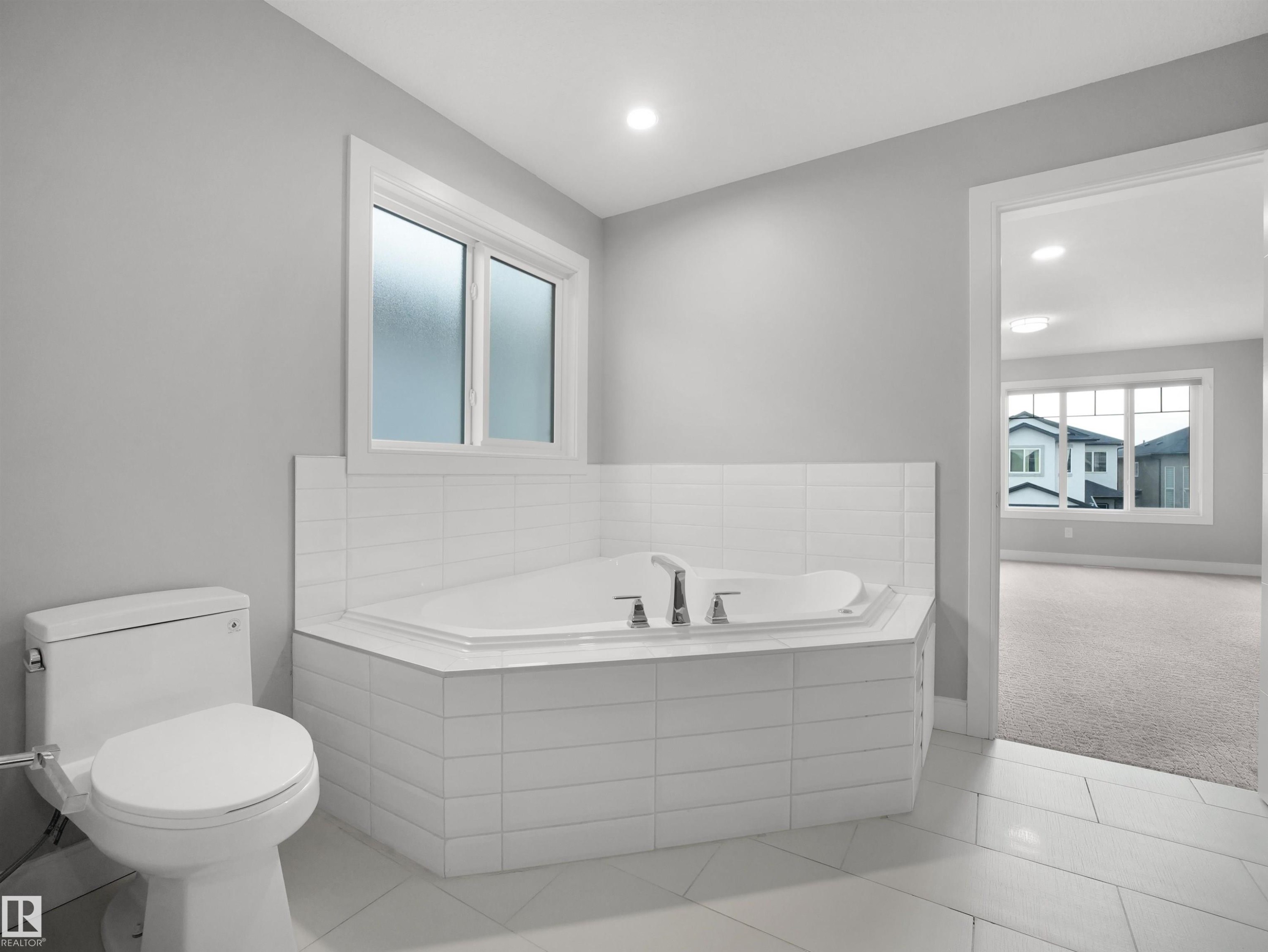 Corner soaking tub with tile surround, white toilet, and recessed lighting - 17020 62 Street Nw, Edmonton, AB - Indoor Photo Showing Bathroom