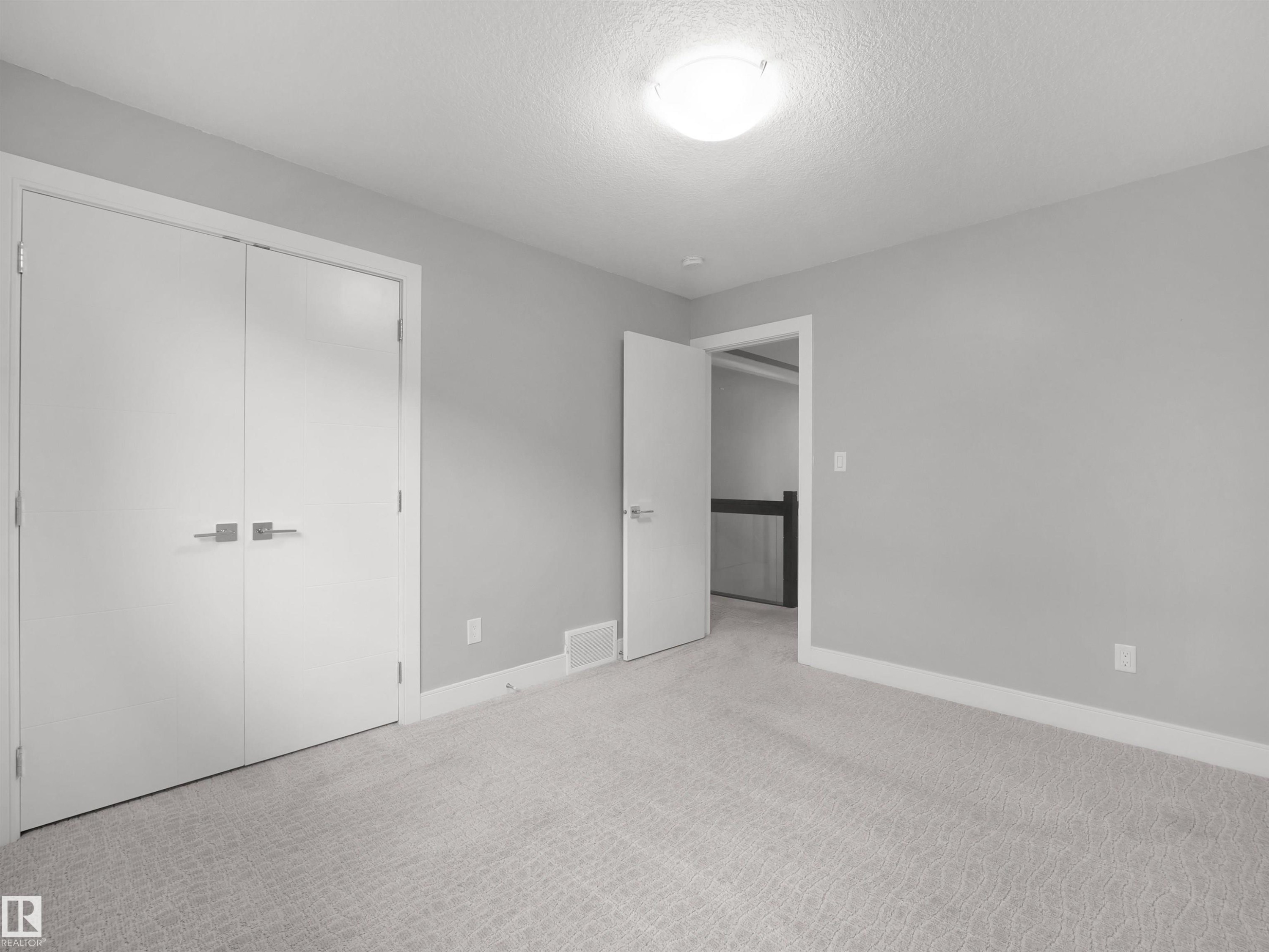 Light gray carpeting, neutral wall paint, white trim, and a flush mount ceiling light fixture - 17020 62 Street Nw, Edmonton, AB - Indoor Photo Showing Other Room