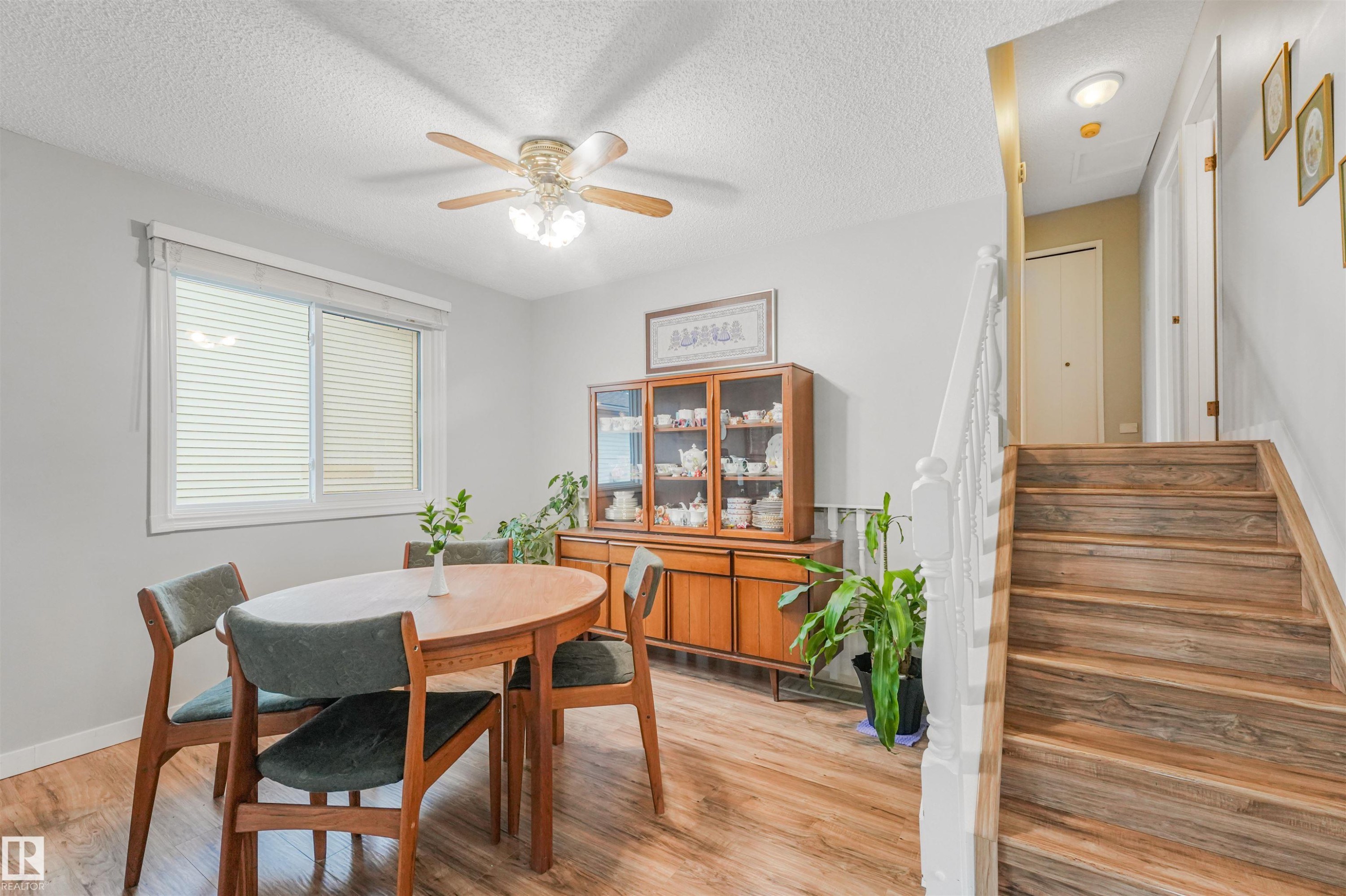 Interior space featuring wood-finish flooring throughout, a window with horizontal blinds, and a ceiling fan with integrated lighting - 18611 57 Avenue Nw, Edmonton, AB - Indoor Photo Showing Dining Room