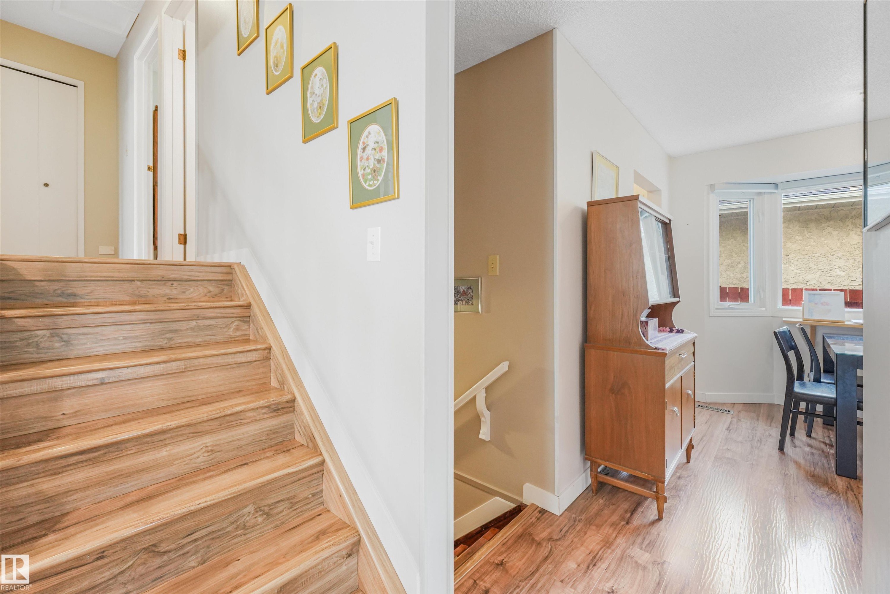 Wood-finish staircase with a white railing and wall accents - 18611 57 Avenue Nw, Edmonton, AB - Indoor Photo Showing Other Room