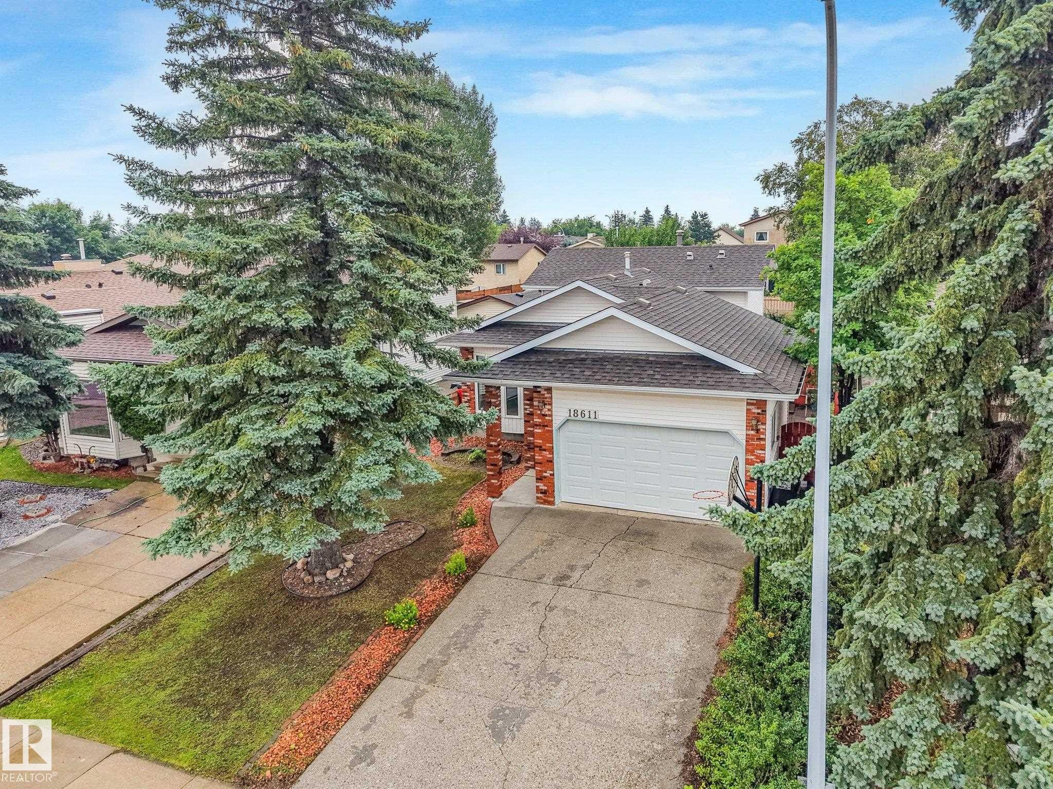 Front exterior with a concrete driveway and an attached garage - 18611 57 Avenue Nw, Edmonton, AB - Outdoor