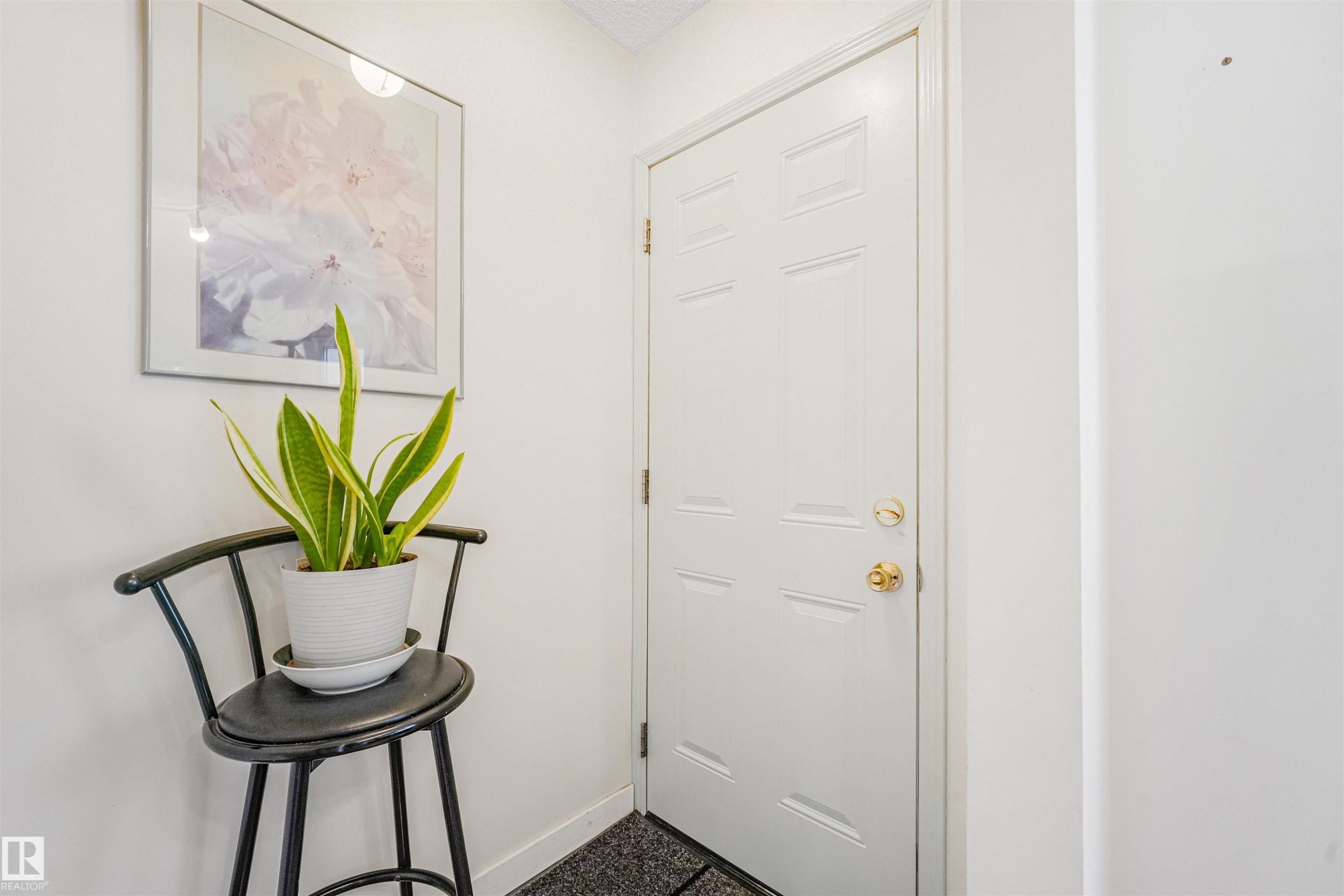White paneled door with brass hardware, set against a light-colored wall - 18611 57 Avenue Nw, Edmonton, AB - Indoor Photo Showing Other Room