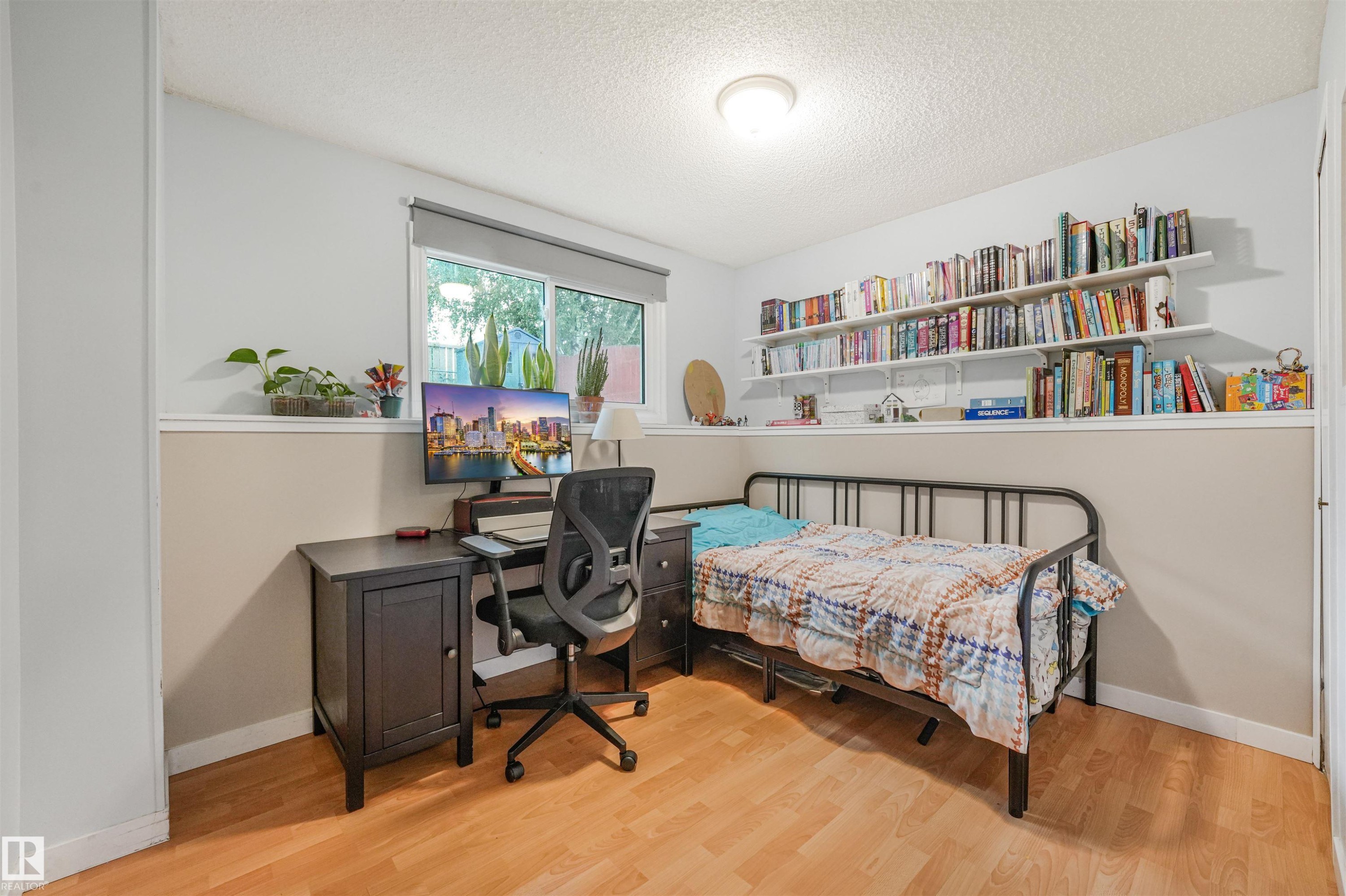 Interior room featuring wood-finish flooring and a window with a roller shade - 18611 57 Avenue Nw, Edmonton, AB - Indoor Photo Showing Bedroom