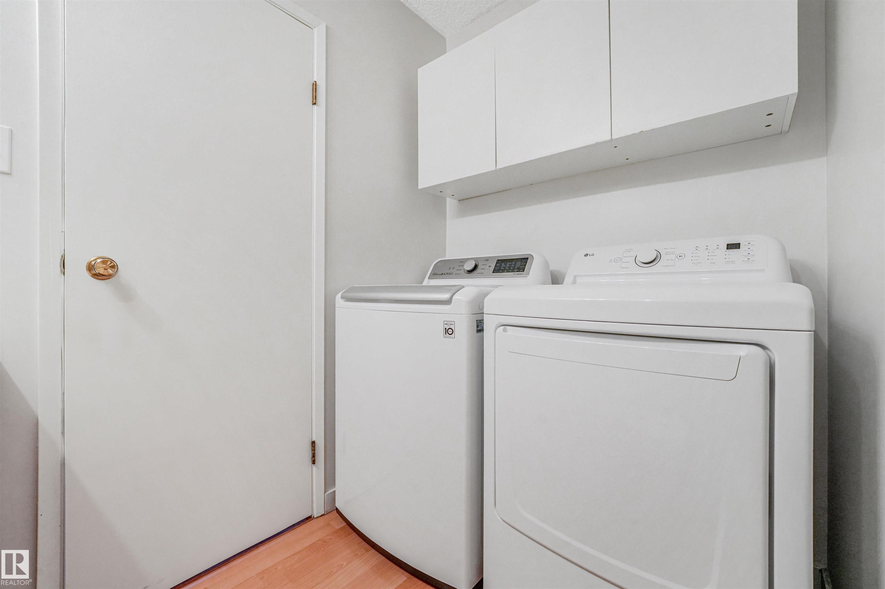 Dedicated laundry area featuring a white top-load washer and front-load dryer - 18611 57 Avenue Nw, Edmonton, AB - Indoor Photo Showing Laundry Room