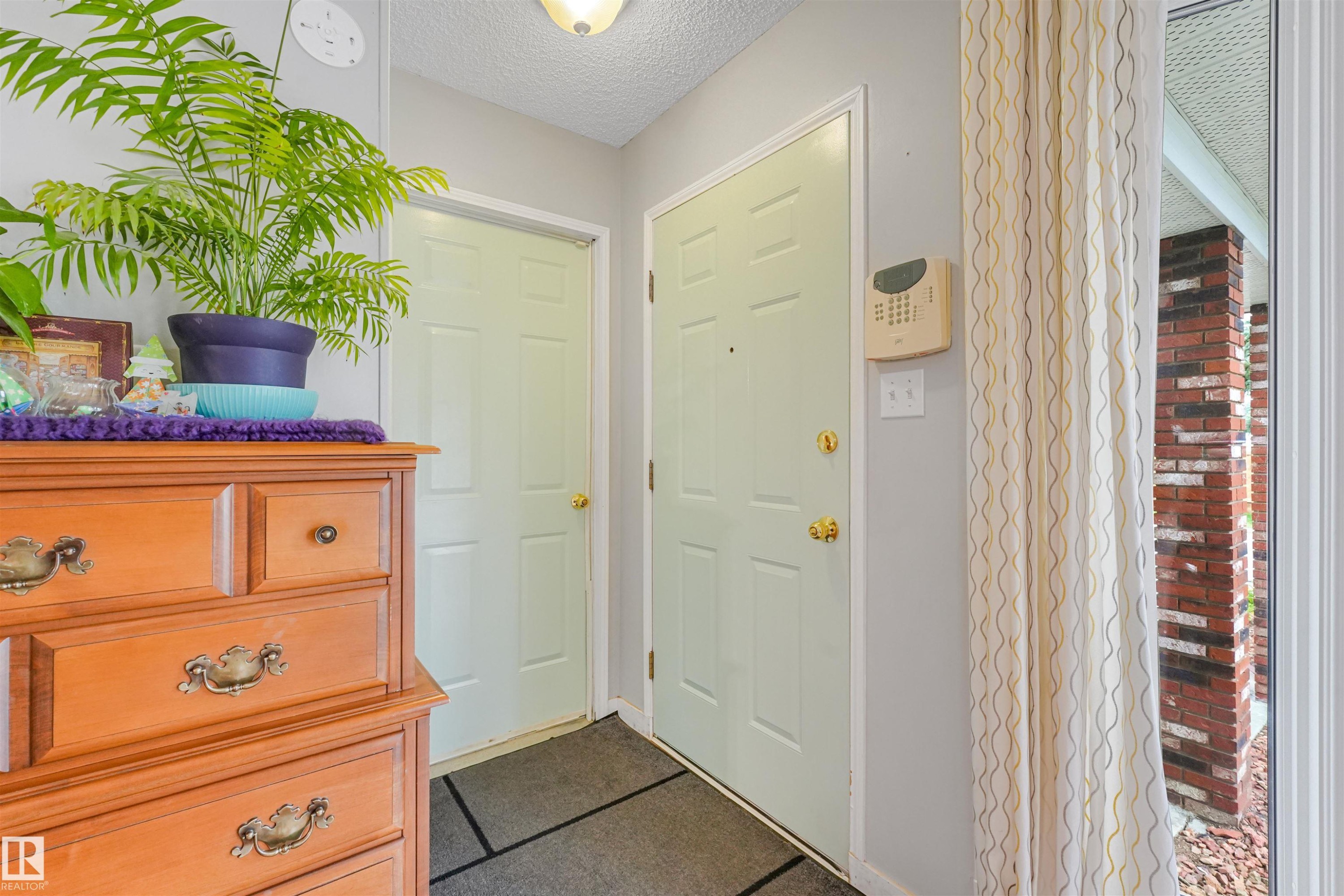 Entryway featuring a light-colored main door with brass hardware and an interior door - 18611 57 Avenue Nw, Edmonton, AB - Indoor Photo Showing Other Room