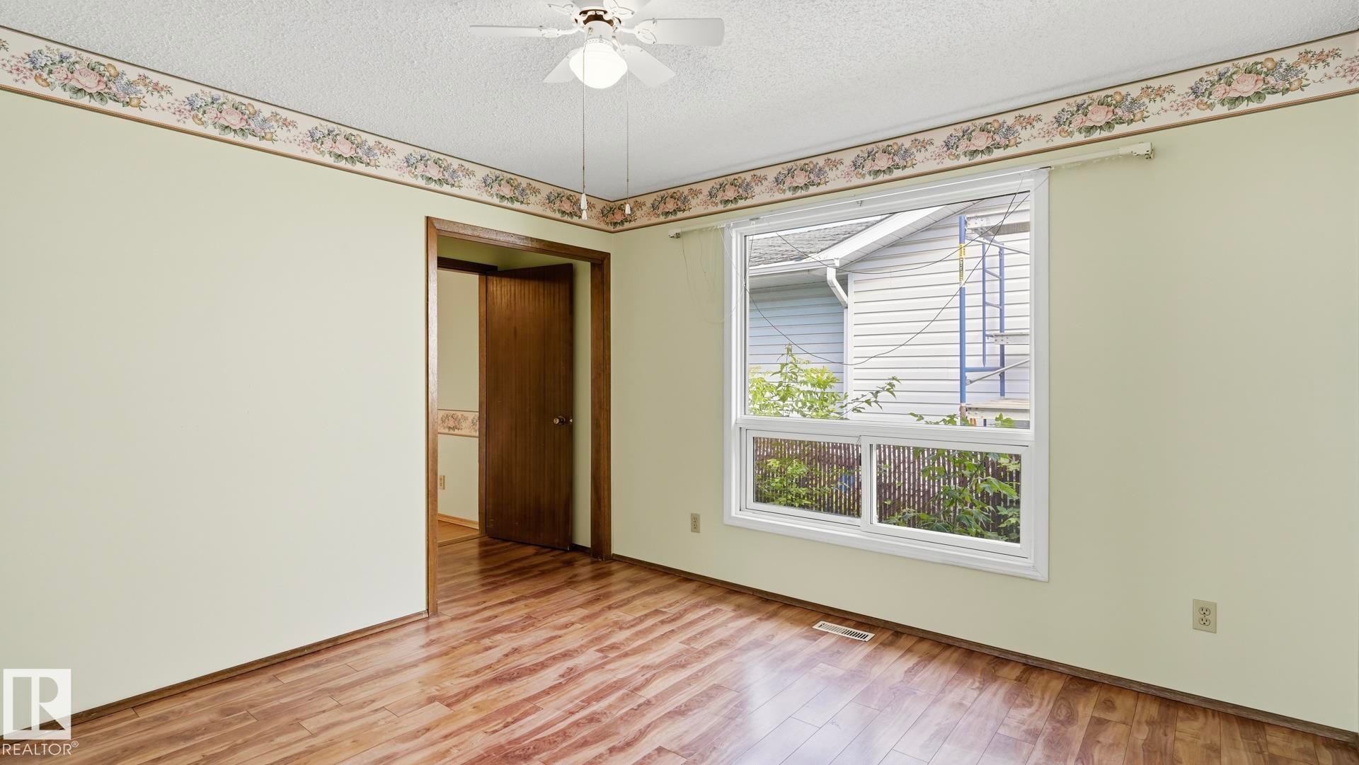 Wood-finish flooring with light-colored walls - 8408 176 Street Nw, Edmonton, AB - Indoor Photo Showing Other Room