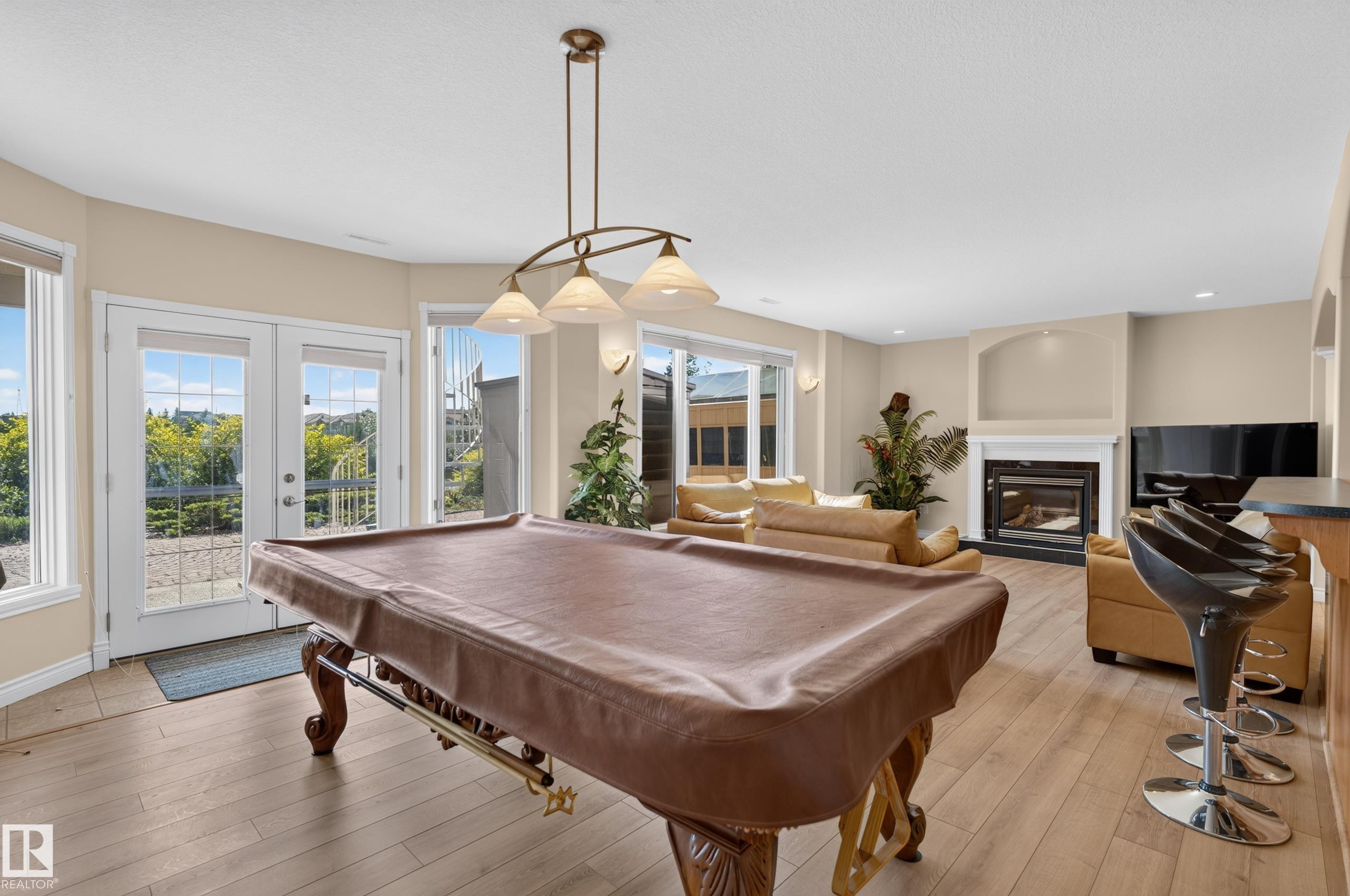 Open-concept room featuring wood-finish flooring, a fireplace with a mantel, and French doors - 13527 158 Avenue Nw, Edmonton, AB - Indoor Photo Showing Other Room With Fireplace