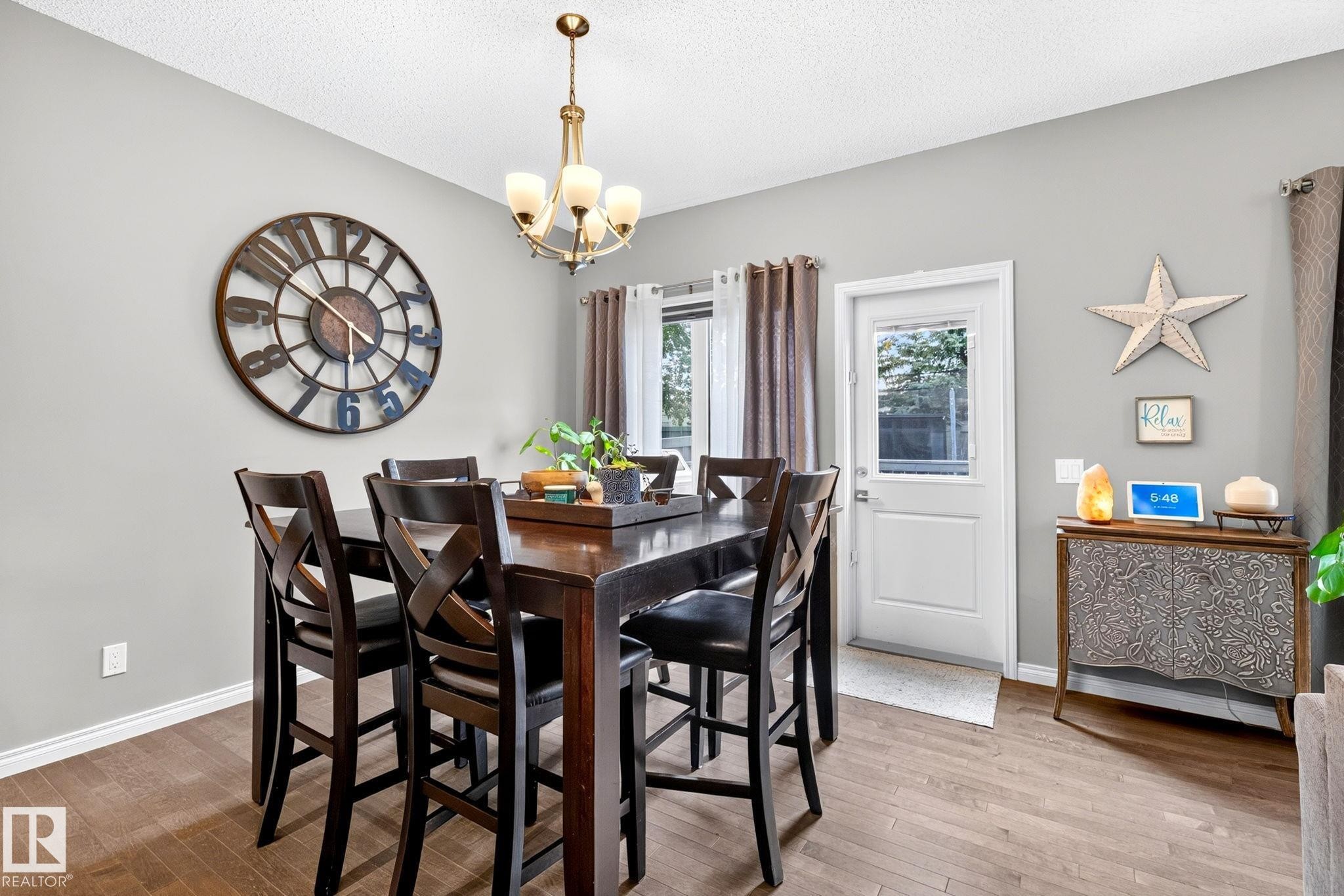 Wood-finish flooring, white walls, and a white door with a window - 16512 140 Street Nw, Edmonton, AB - Indoor Photo Showing Dining Room