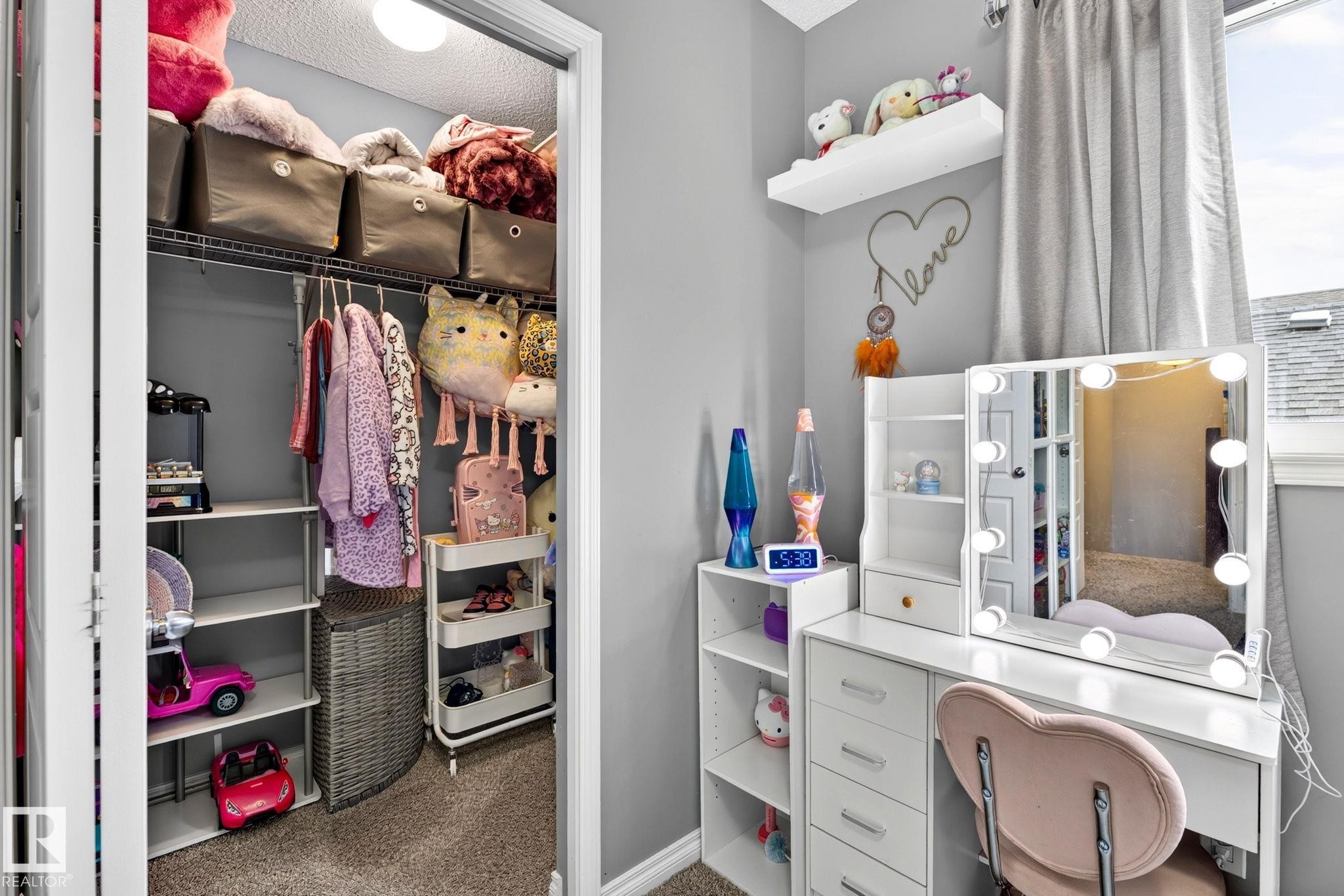 Built-in closet shelving and hanging storage, light gray wall paint, and a built-in window with white trim - 16512 140 Street Nw, Edmonton, AB - Indoor
