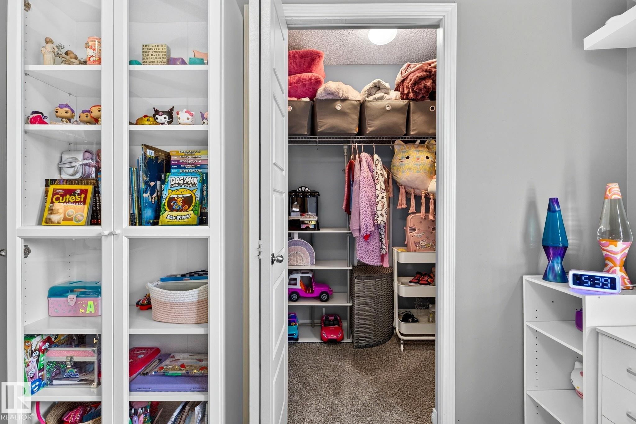 Built-in white shelving, recessed lighting, and a closet with integrated shelving and a hanging rod - 16512 140 Street Nw, Edmonton, AB - Indoor
