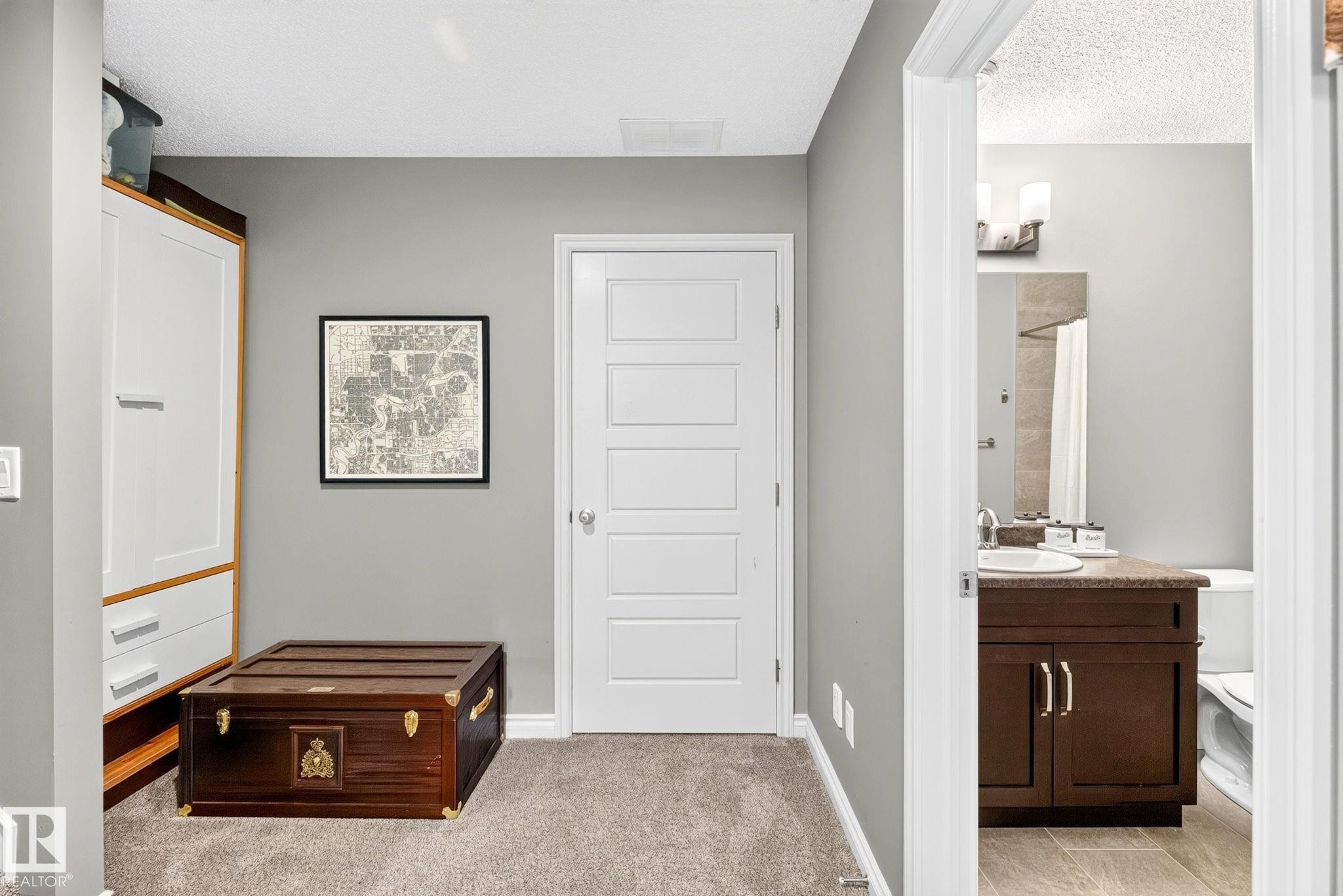 Hallway featuring plush carpeting, a modern five-panel door, and smooth wall finishes - 16512 140 Street Nw, Edmonton, AB - Indoor Photo Showing Other Room