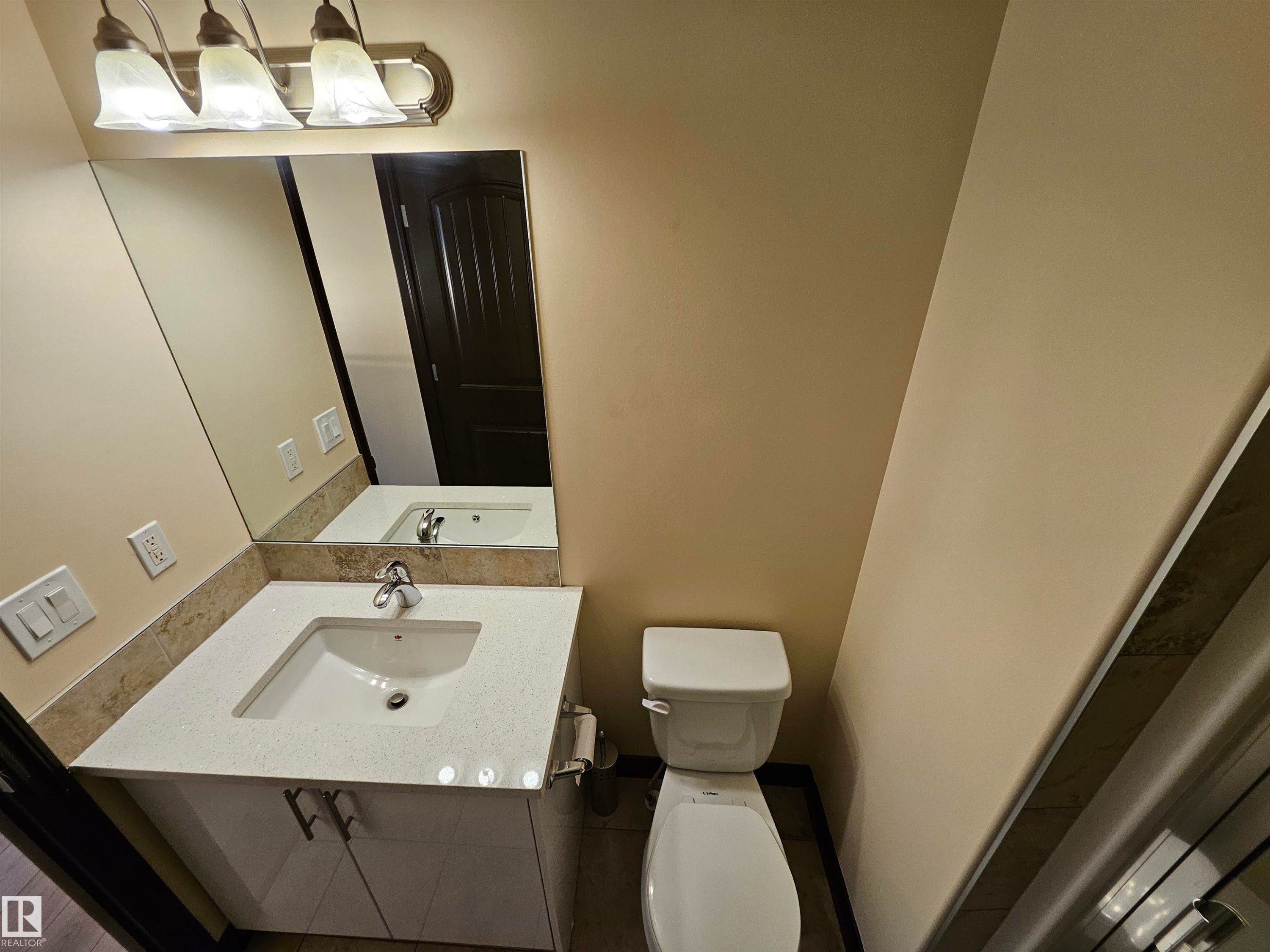 Vanity with a rectangular undermount sink, solid surface countertop, and matching backsplash - 11625 88 Street Nw, Edmonton, AB