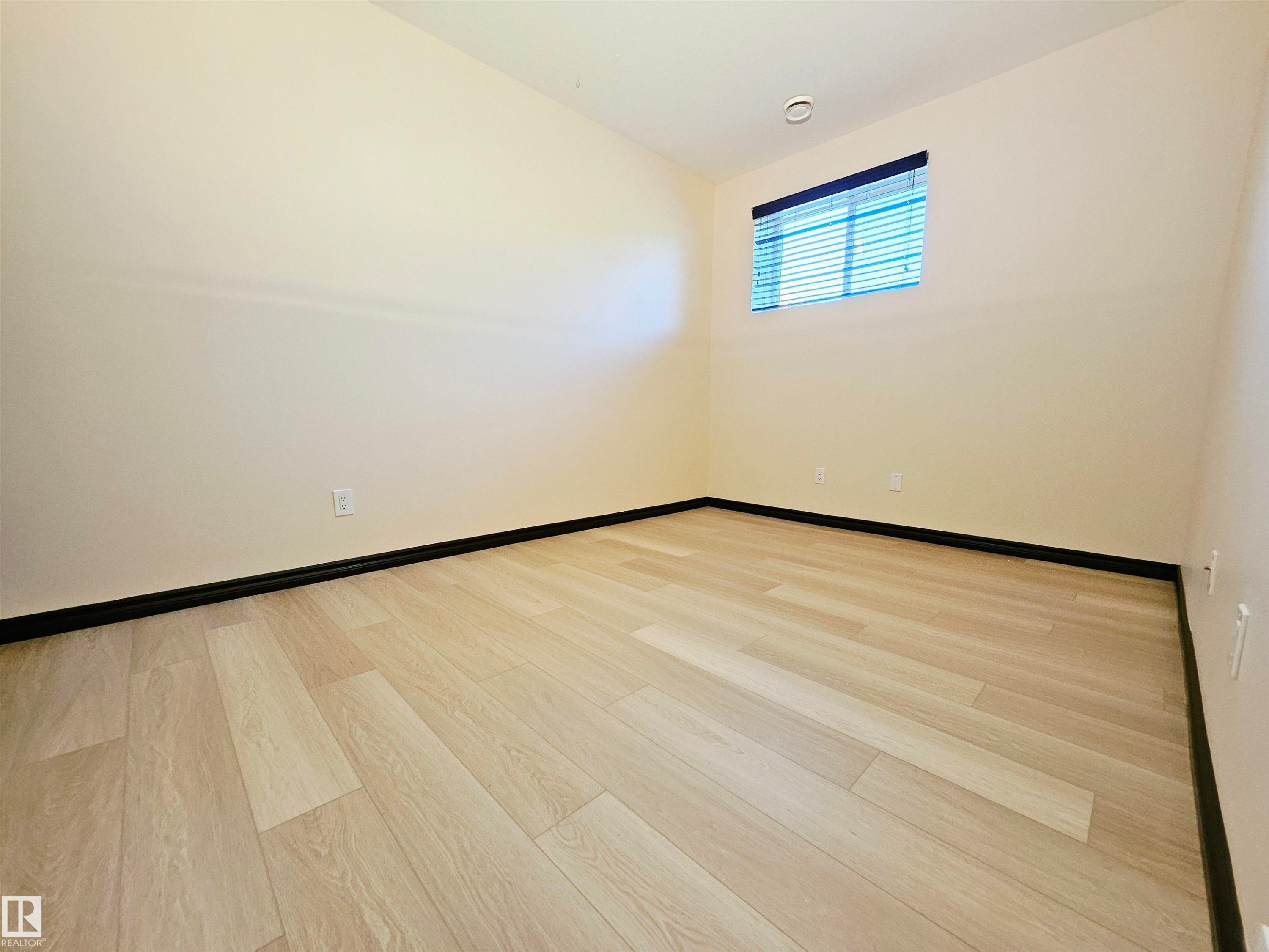 Light-toned wood-finish flooring, recessed lighting, and a window with blinds - 11625 88 Street Nw, Edmonton, AB