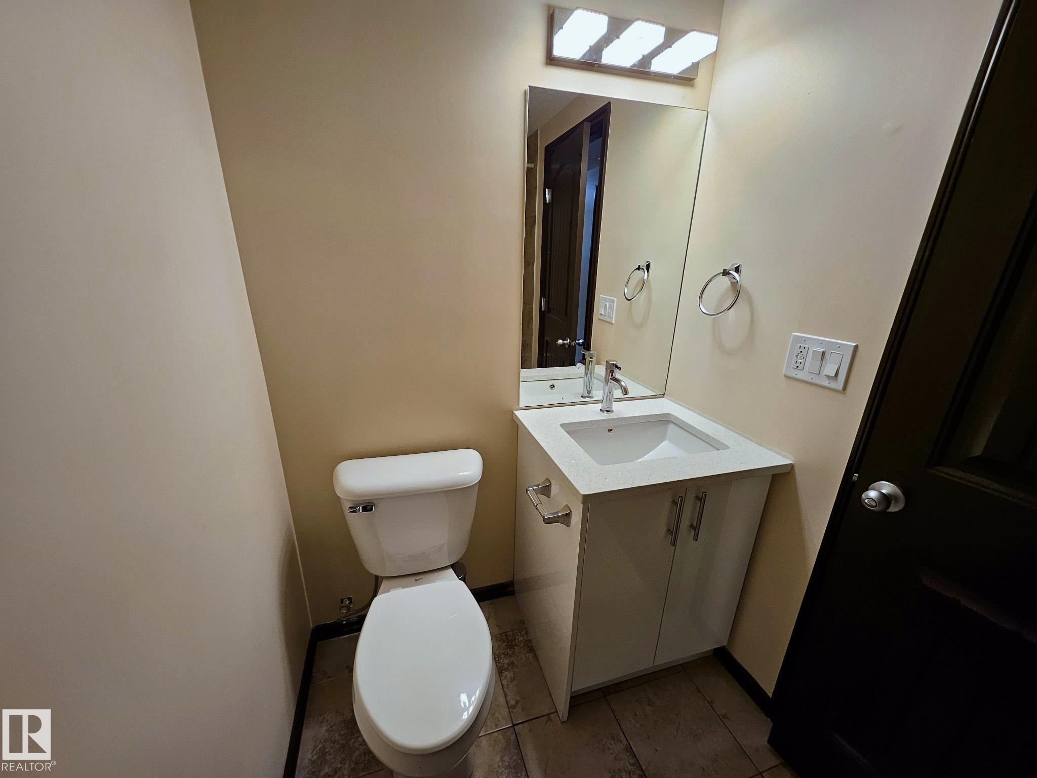 Modern vanity with a rectangular integrated sink, chrome faucet, and mirrored medicine cabinet - 11625 88 Street Nw, Edmonton, AB