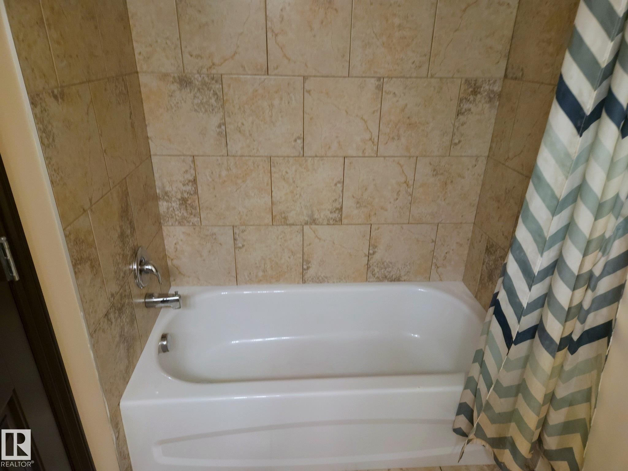 Tile surround with a white bathtub and chrome fixtures - 11625 88 Street Nw, Edmonton, AB