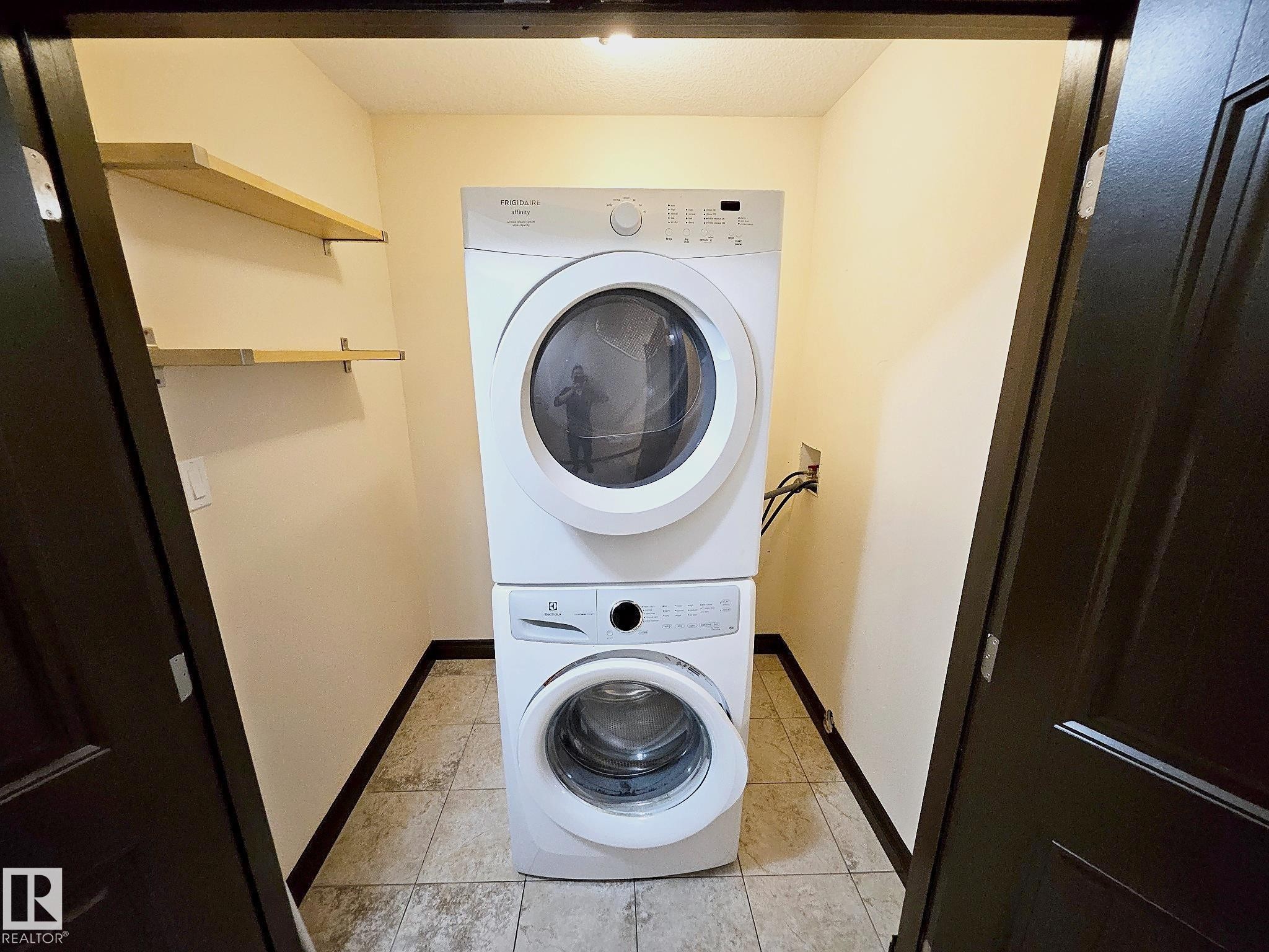 Stacked laundry appliances, integrated shelving, and tile flooring - 11625 88 Street Nw, Edmonton, AB