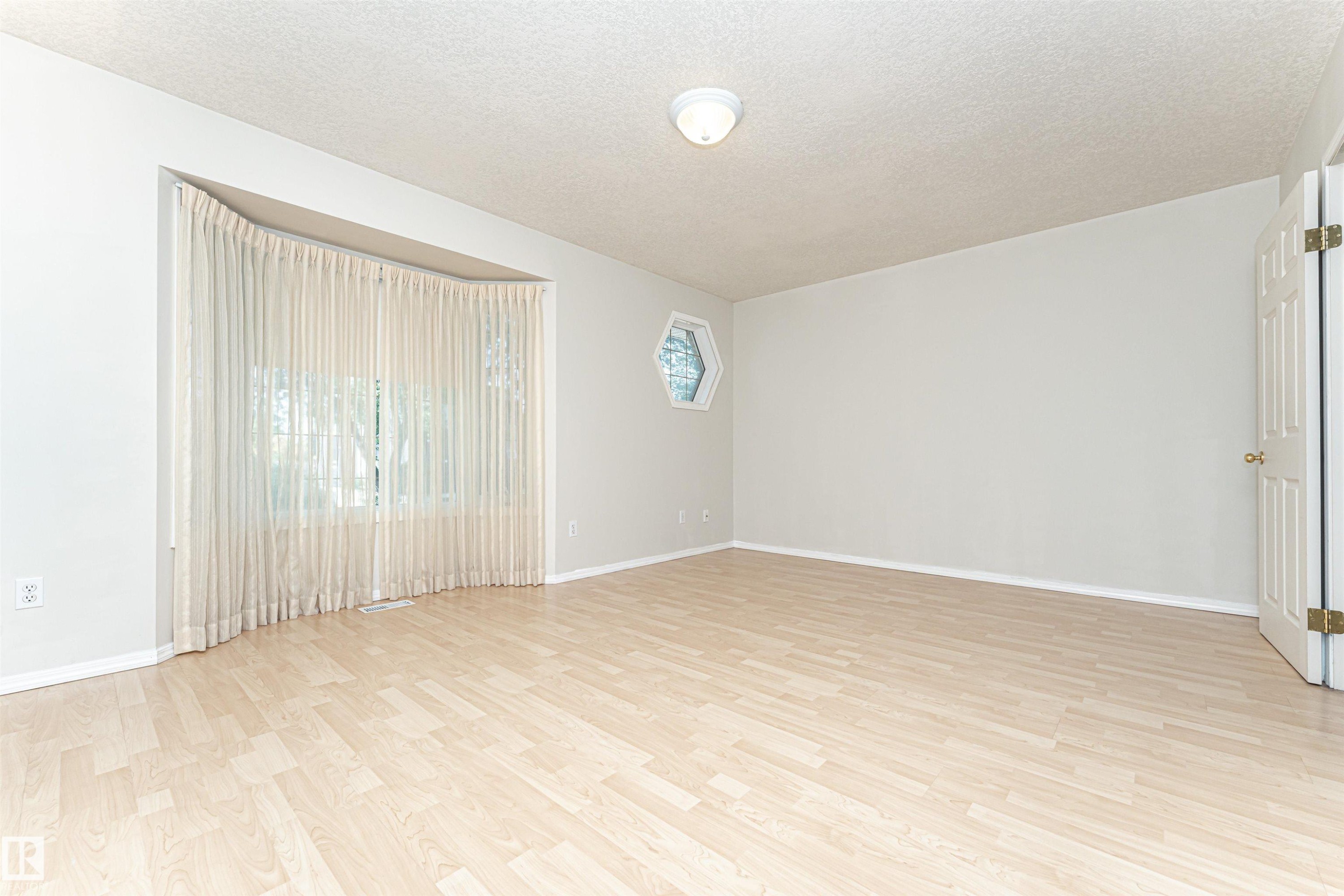 Light wood-finish flooring, hexagon window, and a curved window wall - 12241 93 Street Nw, Edmonton, AB - Indoor Photo Showing Other Room