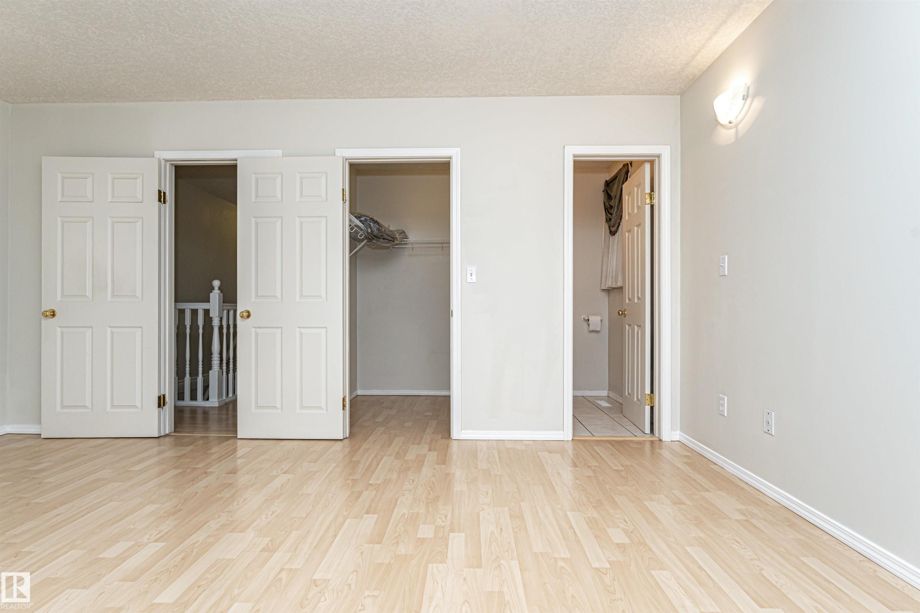 Wood-finish flooring throughout, with white trim and light gray walls - 12241 93 Street Nw, Edmonton, AB - Indoor Photo Showing Other Room