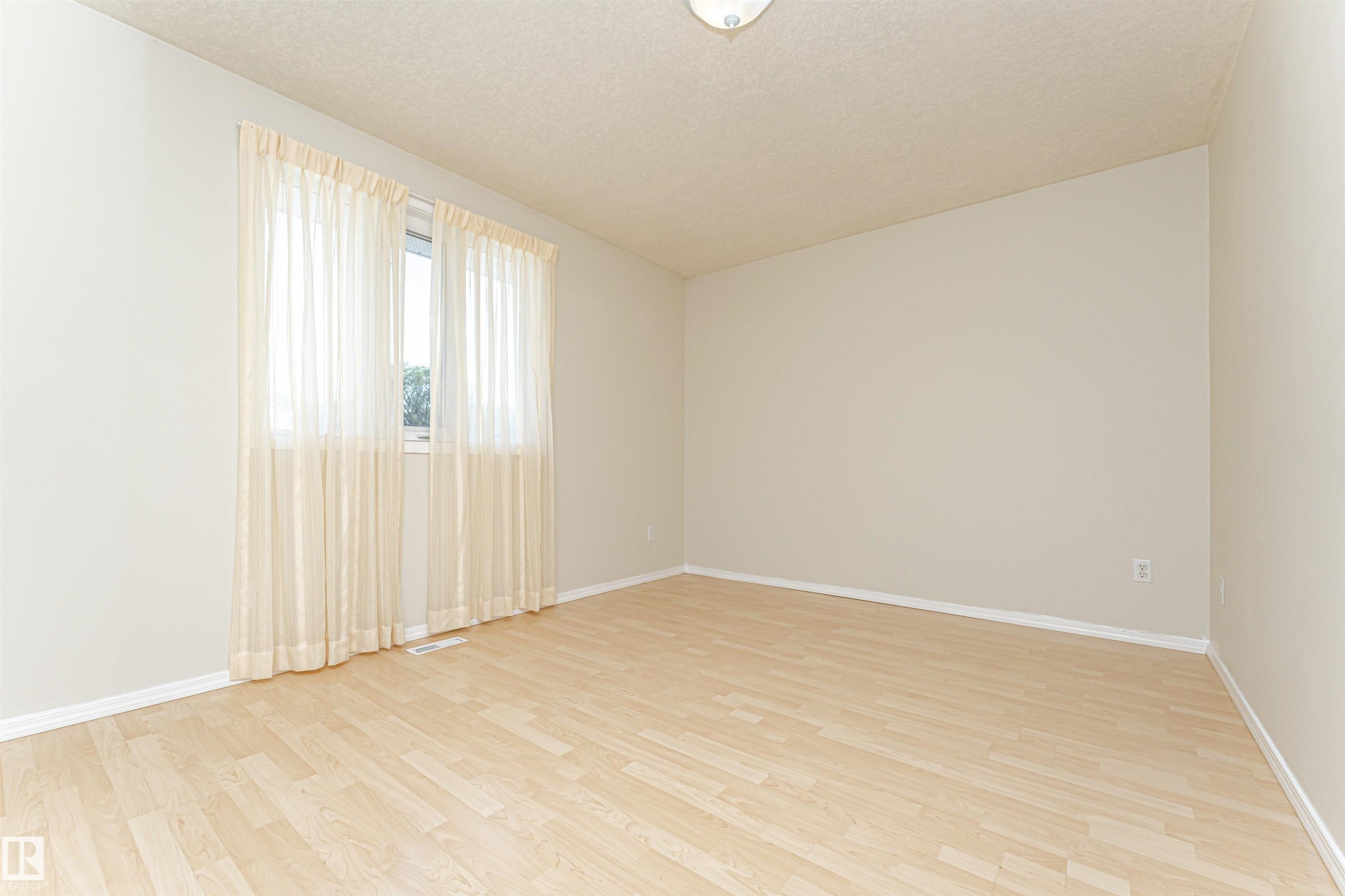 Light-toned wood-finish flooring complements the neutral wall color - 12241 93 Street Nw, Edmonton, AB - Indoor Photo Showing Other Room
