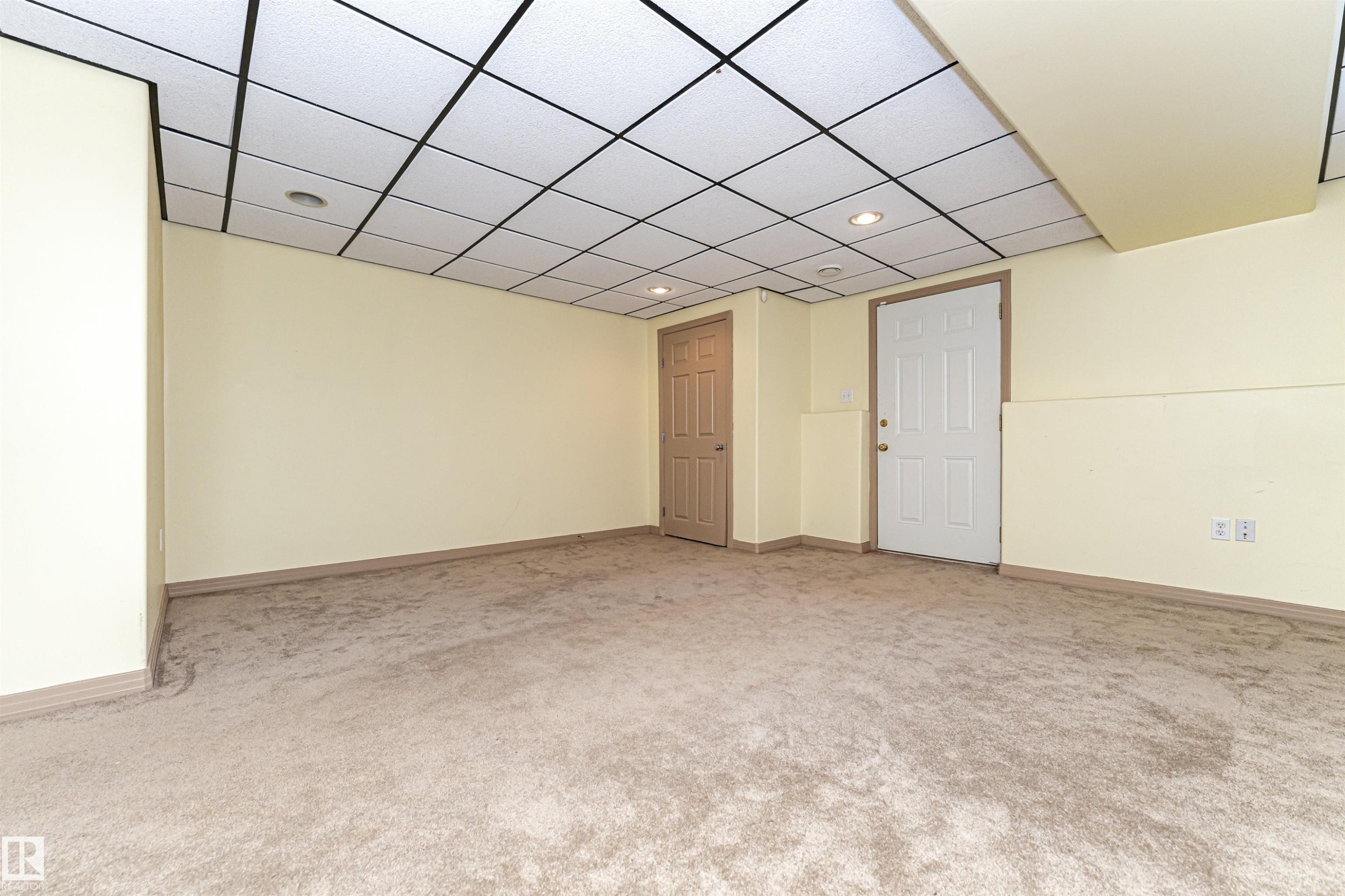 Wall-to-wall carpeting, drop ceiling with integrated lighting, and two panel doors - 12241 93 Street Nw, Edmonton, AB - Indoor Photo Showing Other Room