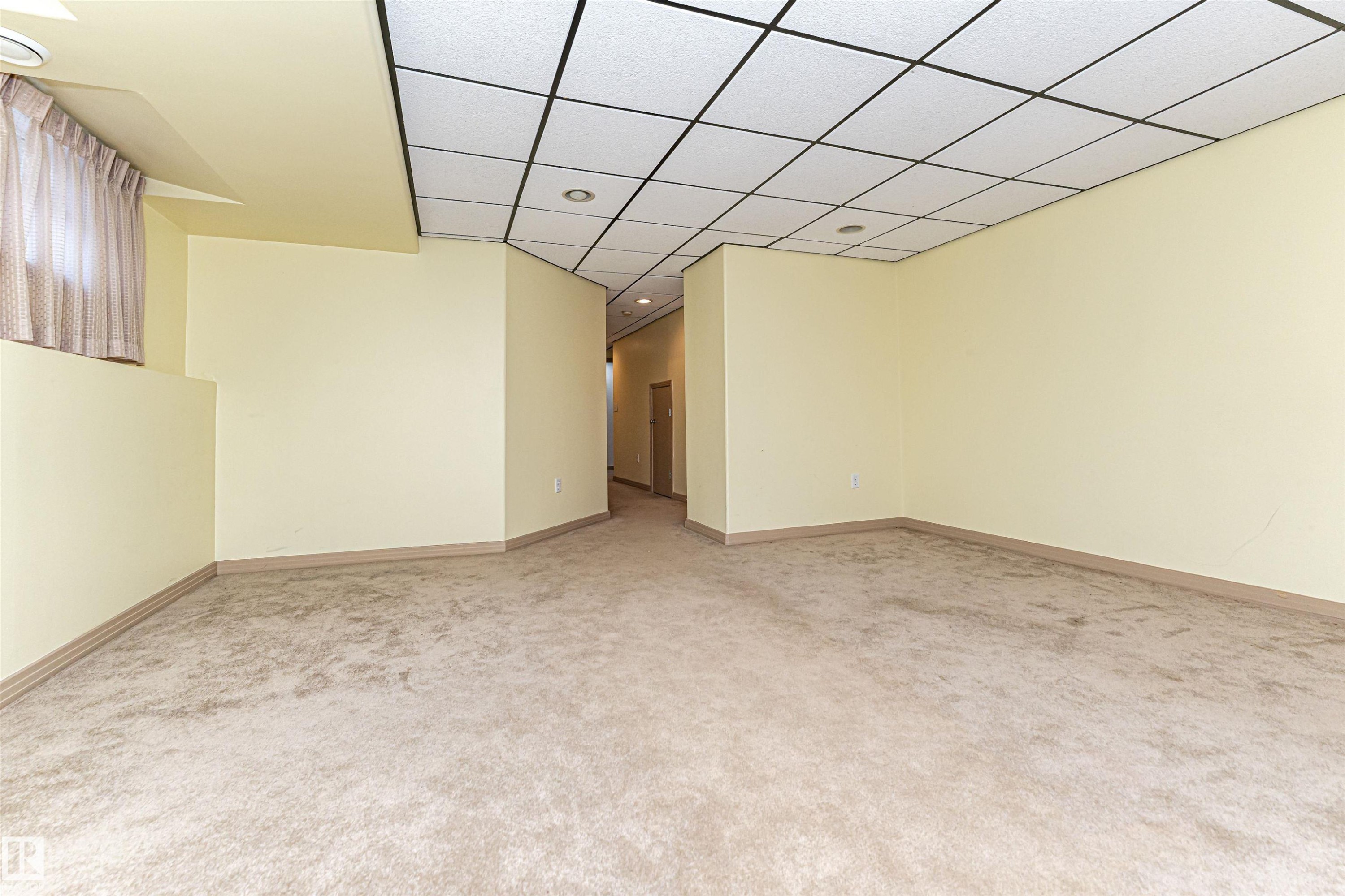 Recessed lighting, drop ceiling, wall-to-wall carpeting, light-toned walls, and a window with curtain treatment - 12241 93 Street Nw, Edmonton, AB - Indoor Photo Showing Other Room