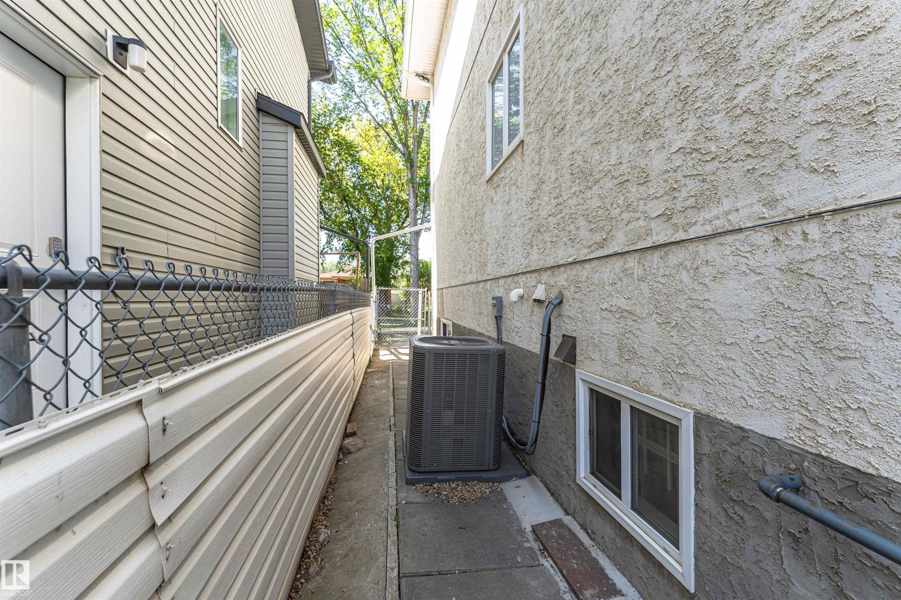 Stucco exterior with a ground-level window - 12241 93 Street Nw, Edmonton, AB - Outdoor With Exterior
