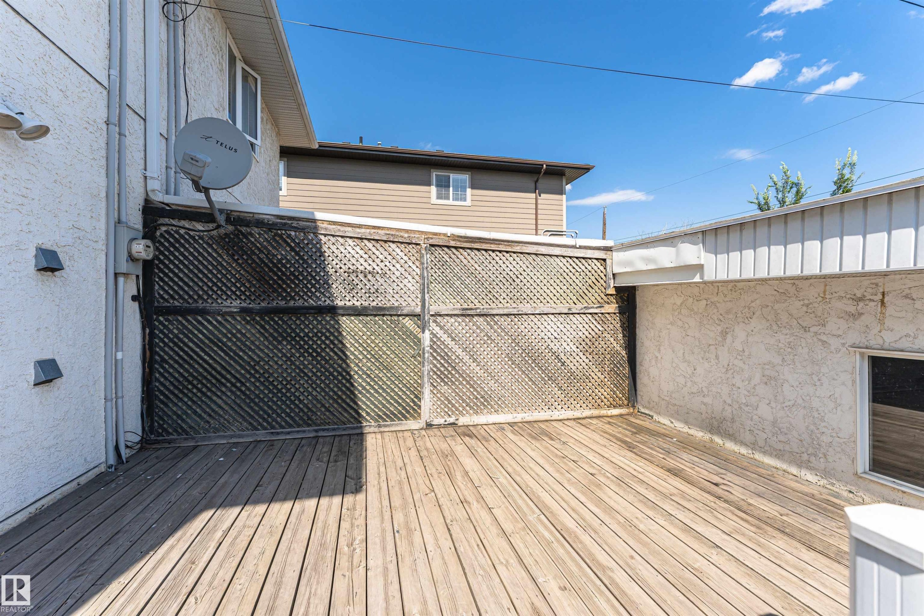 Expansive wood-plank deck with lattice privacy screening - 12241 93 Street Nw, Edmonton, AB - Outdoor With Deck Patio Veranda With Exterior