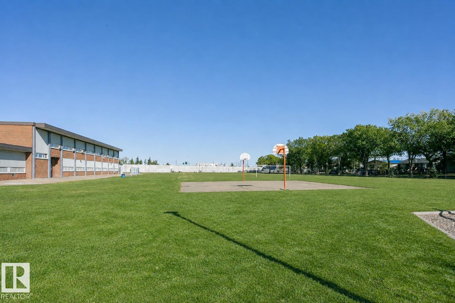Expansive green space featuring a paved court with two basketball hoops - 12241 93 Street Nw, Edmonton, AB - Outdoor