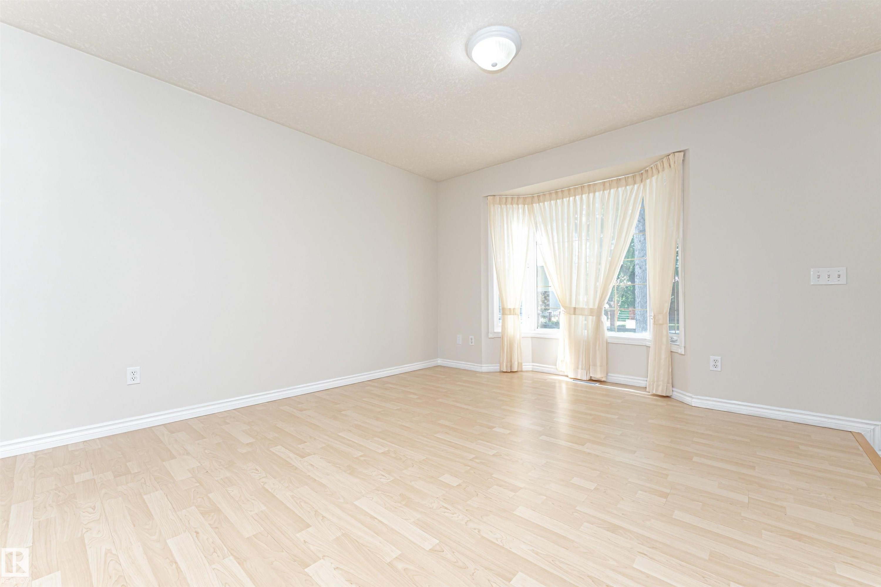 Wood-finish flooring, bay window, light wall tones, and recessed ceiling light - 12241 93 Street Nw, Edmonton, AB - Indoor Photo Showing Other Room