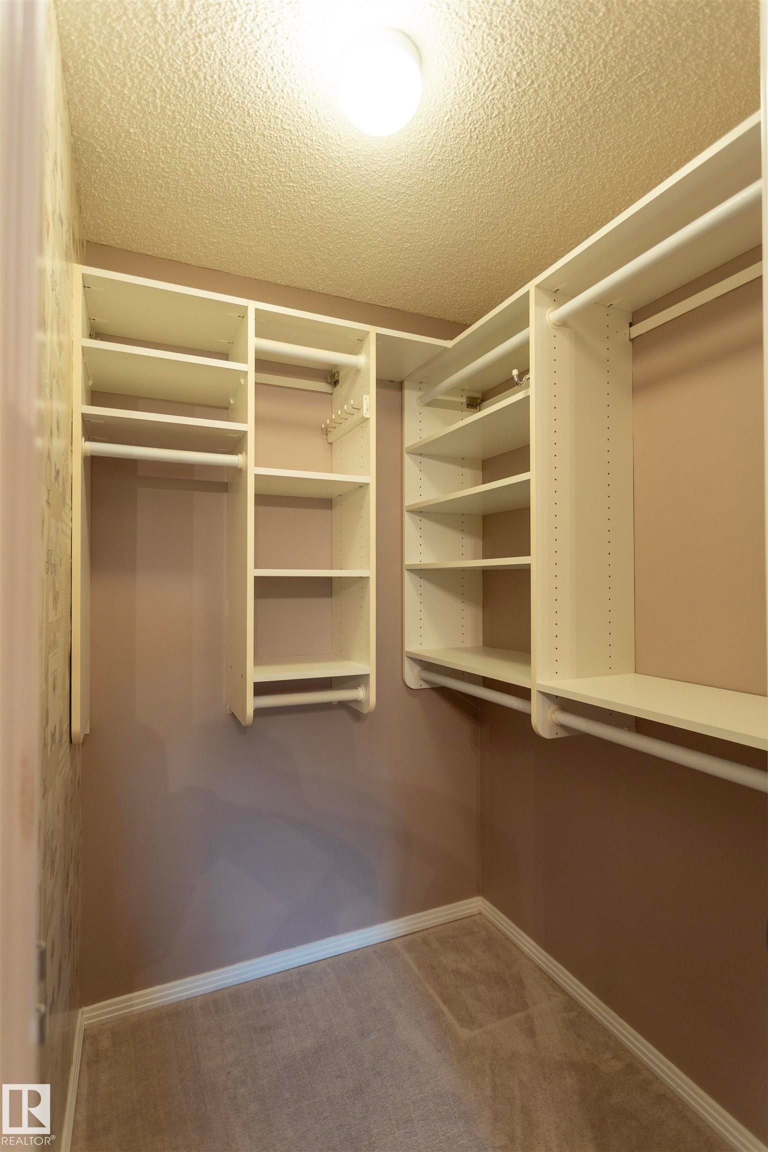 Custom closet organization system featuring shelving and hanging rods - #204 2420 108 St Nw, Edmonton, AB