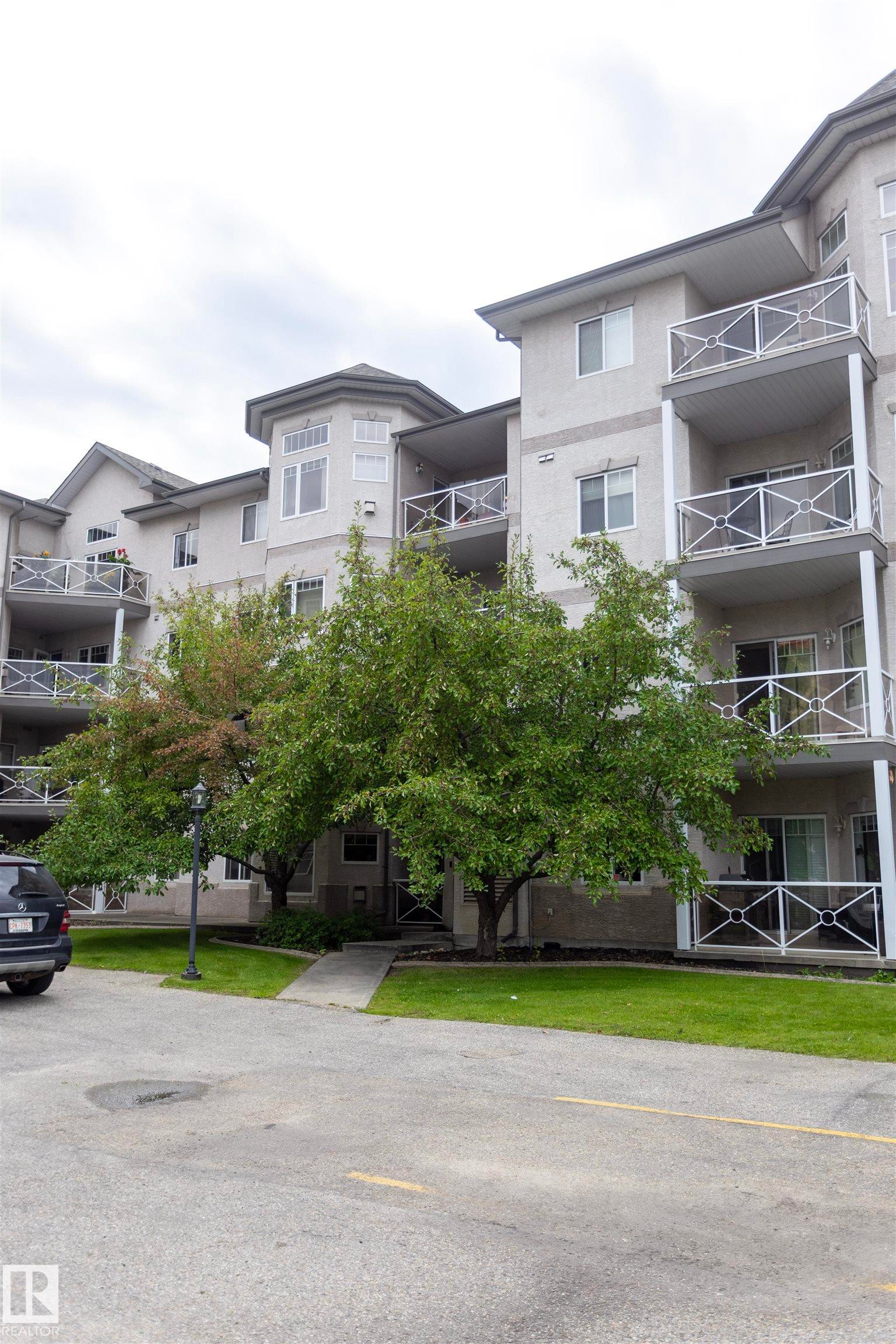 Multi-story building with multiple balconies featuring white decorative railings - #204 2420 108 St Nw, Edmonton, AB