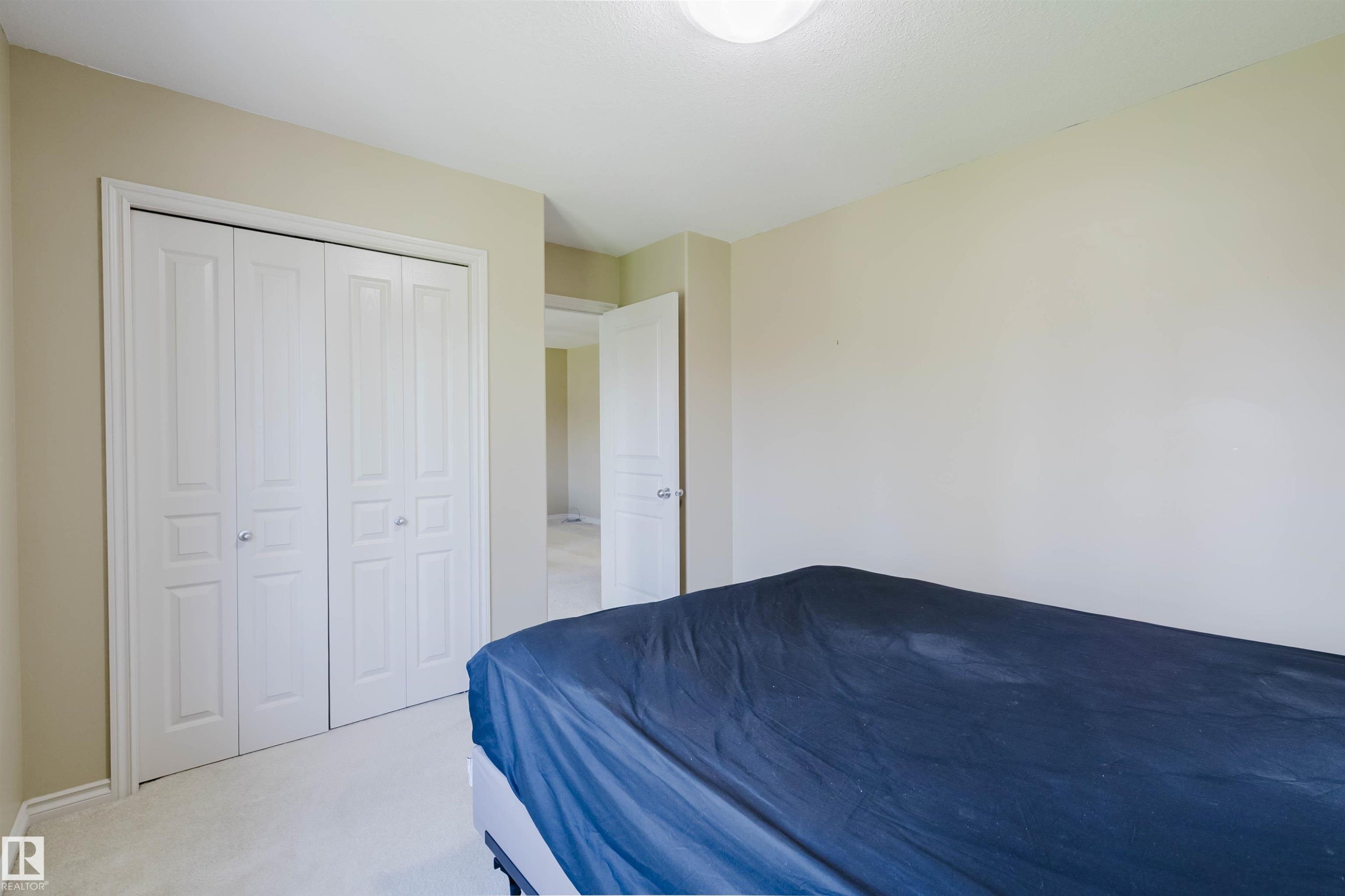 White bi-fold closet doors with round chrome hardware - 864 Armitage Wynd Sw, Edmonton, AB - Indoor Photo Showing Bedroom