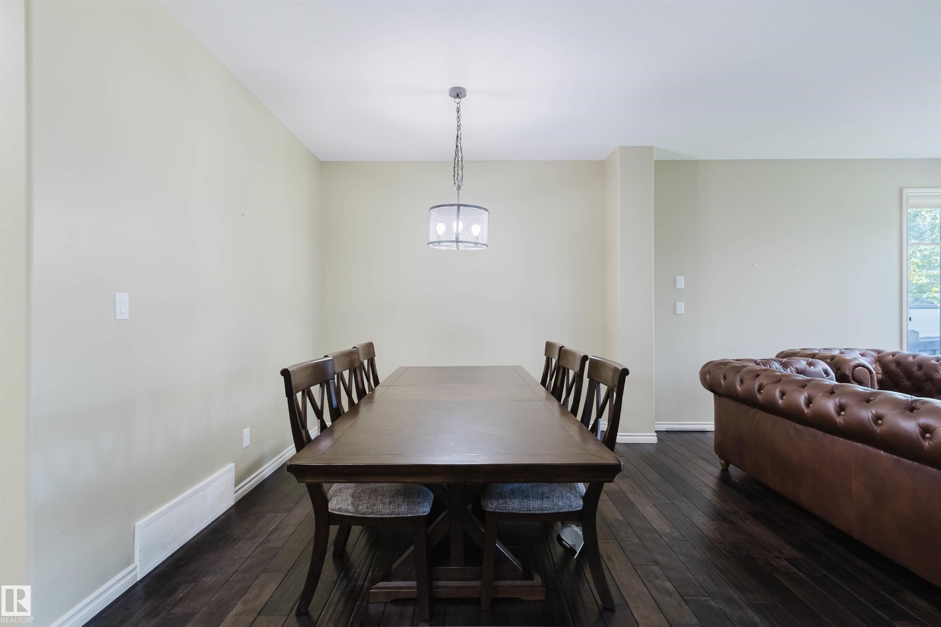 Dark wood-finish flooring with light-toned walls and white trim - 864 Armitage Wynd Sw, Edmonton, AB - Indoor Photo Showing Dining Room