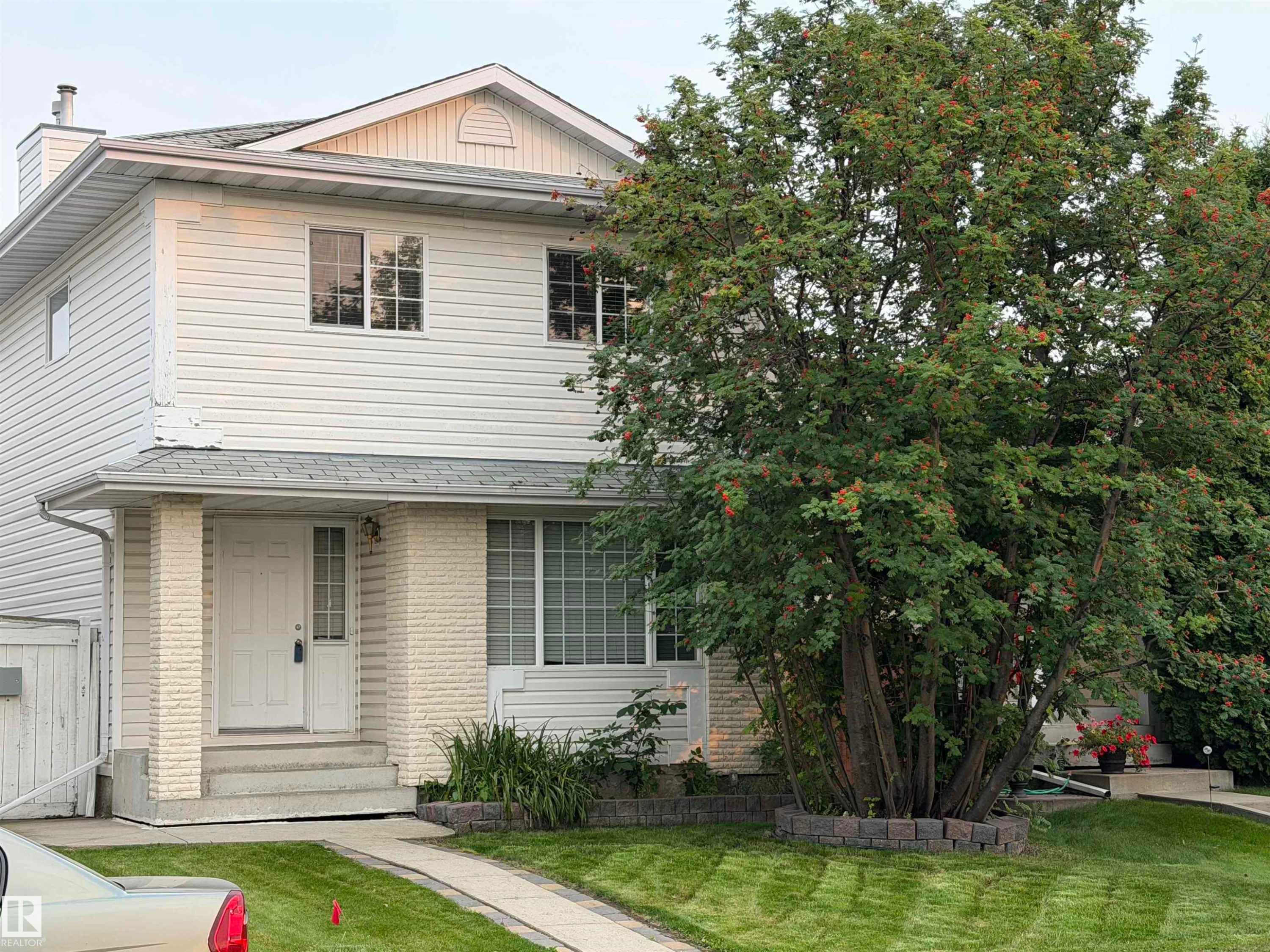 Two-story residential structure featuring white siding and a prominent front entrance with white brick accents - 1535 80A Street Nw, Edmonton, AB - Outdoor