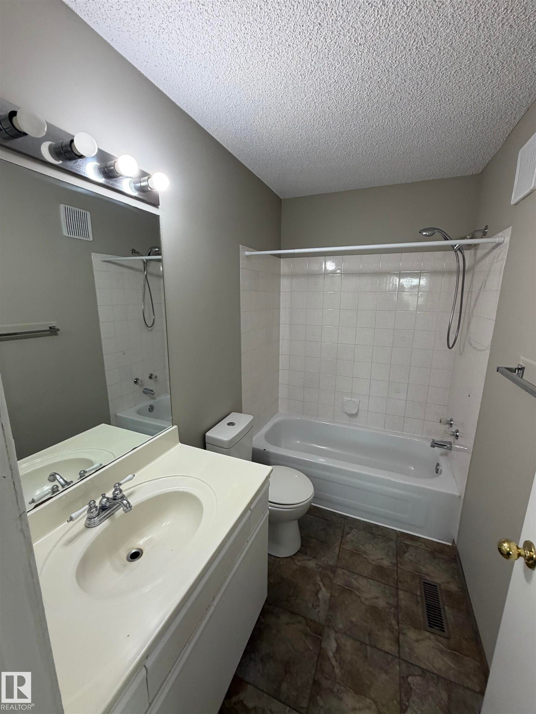 Vanity with integrated sink, chrome faucet, and overhead lighting - 1535 80A Street Nw, Edmonton, AB - Indoor Photo Showing Bathroom