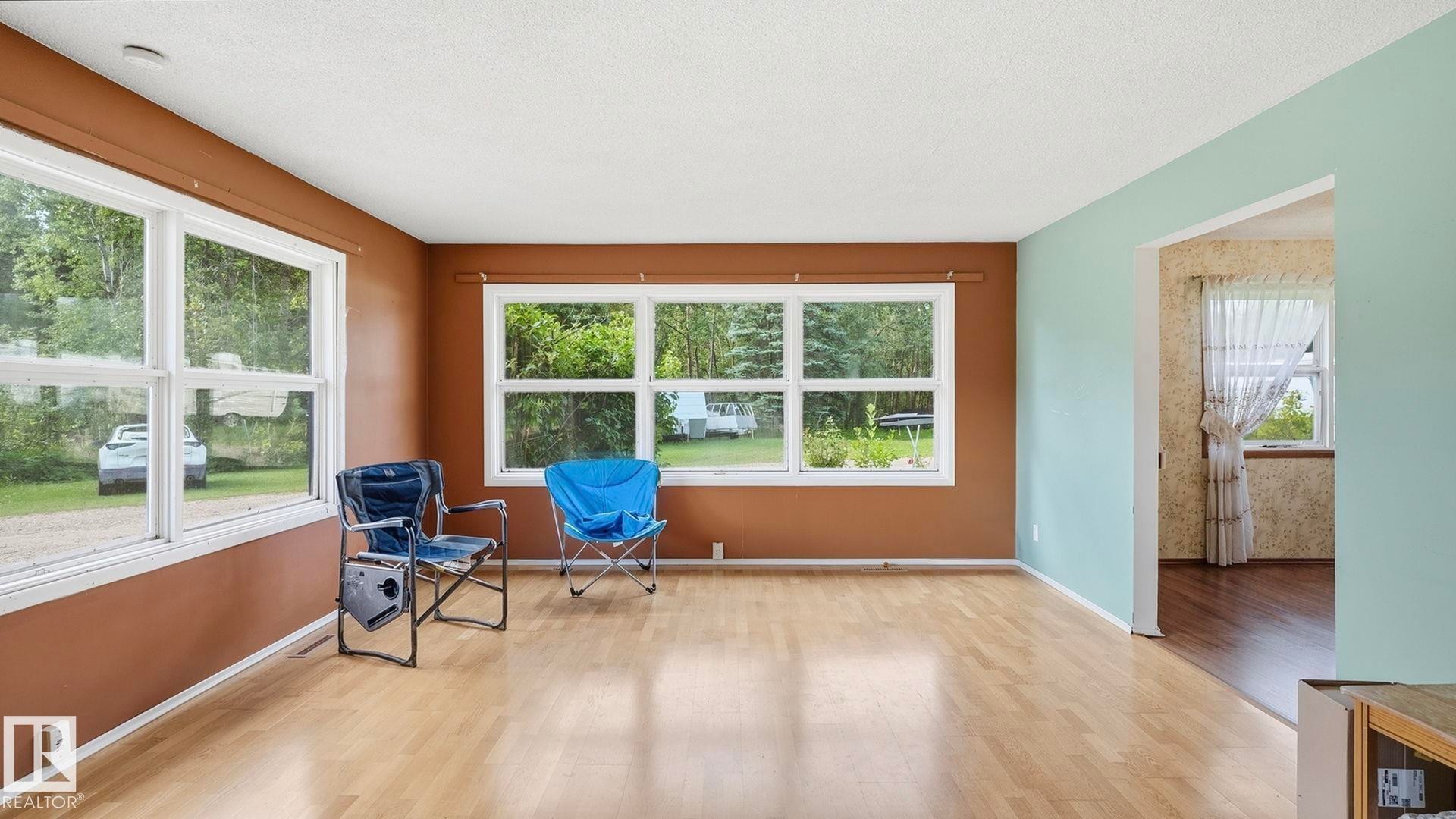 Light wood-finish flooring with multiple windows providing natural illumination - 52012 Hwy 21, Rural Strathcona County, AB - Indoor