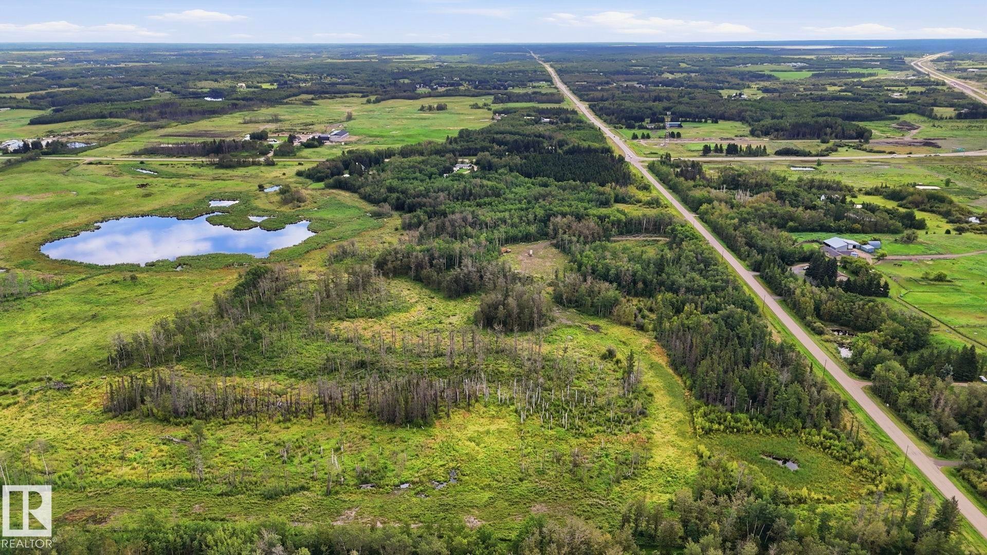 Expansive treed landscape with a visible pond and a distant highway - 52012 Hwy 21, Rural Strathcona County, AB - Outdoor With View