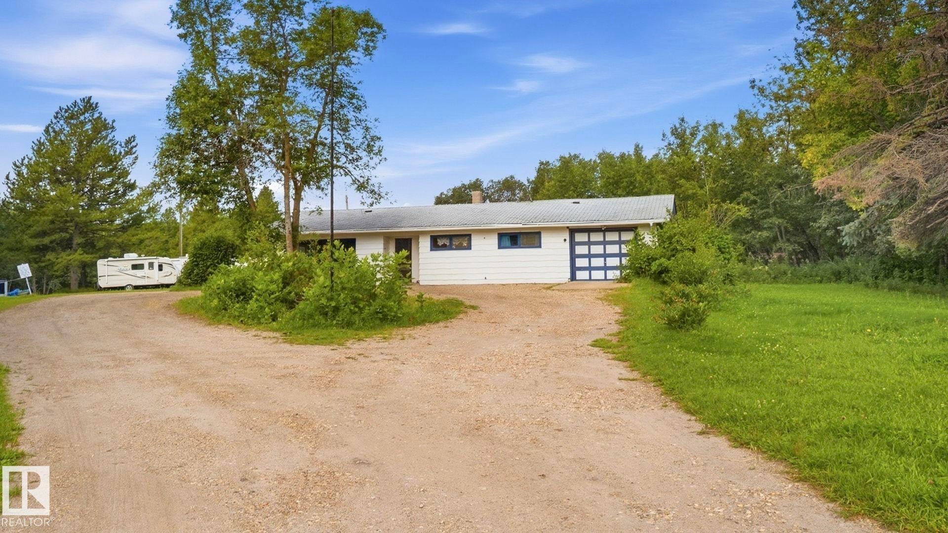 White exterior with blue trim accents and a two-car garage - 52012 Hwy 21, Rural Strathcona County, AB - Outdoor