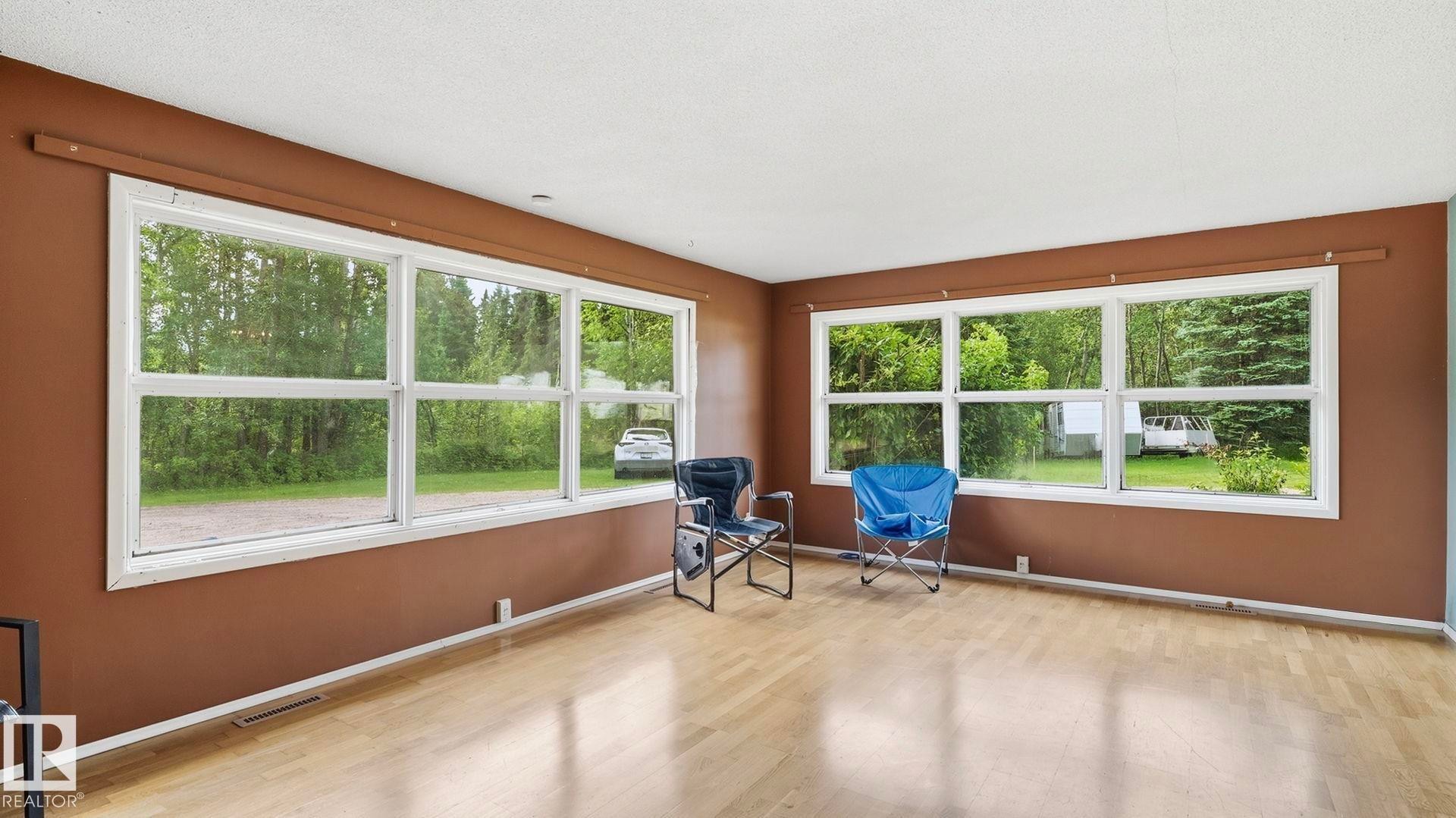 Wood-finish flooring, two large multi-pane windows, and a white ceiling - 52012 Hwy 21, Rural Strathcona County, AB - Indoor