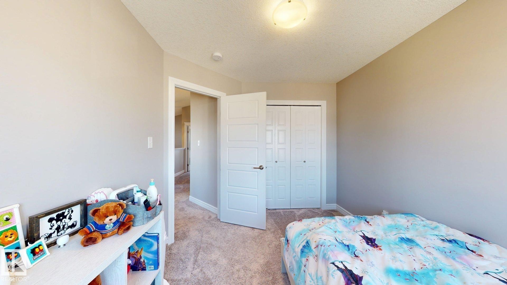 Neutral wall tones, textured carpet, and a white paneled door - 17359 49 Street Nw, Edmonton, AB - Indoor Photo Showing Bedroom
