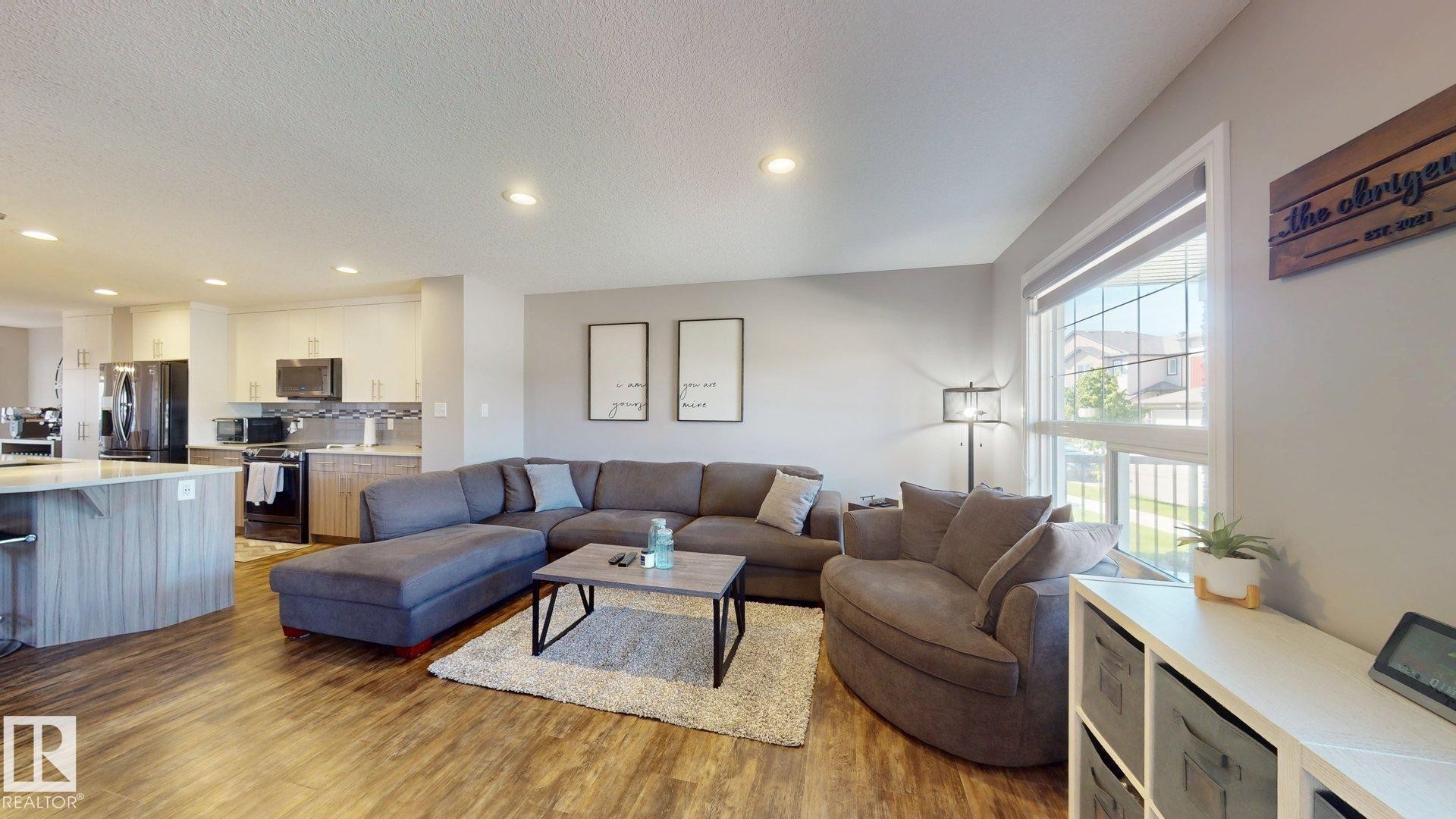 Open-concept living area with wood-finish flooring, recessed lighting, and a large window - 17359 49 Street Nw, Edmonton, AB - Indoor Photo Showing Living Room
