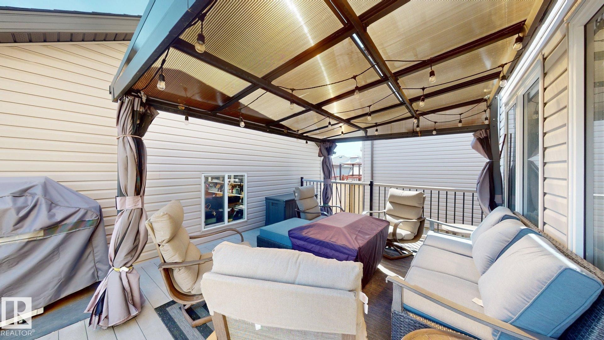 Covered outdoor patio with string lighting, siding exterior, and privacy railing - 17359 49 Street Nw, Edmonton, AB - Outdoor With Deck Patio Veranda With Exterior