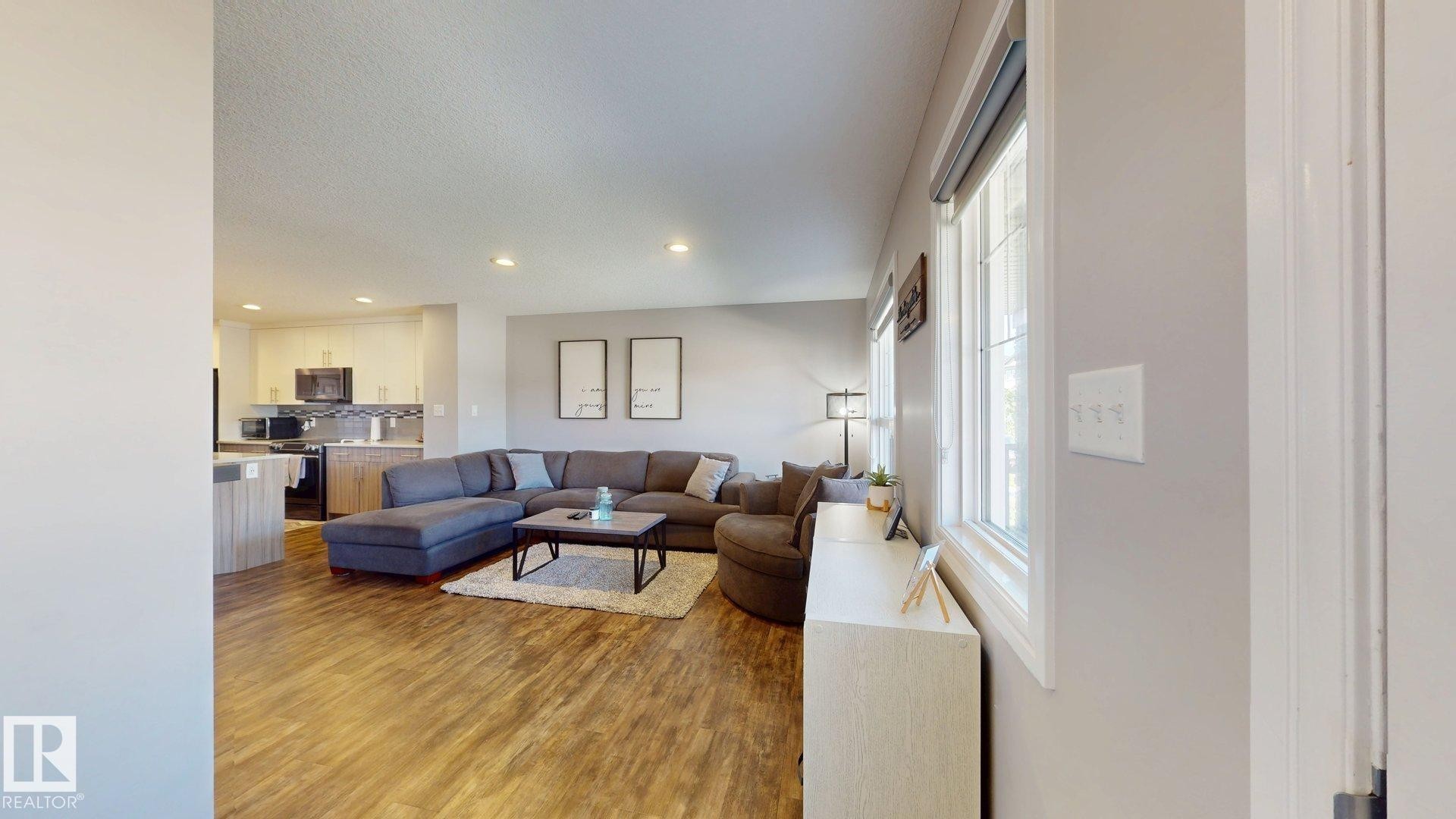 Wood-finish flooring throughout, recessed lighting, and white trim - 17359 49 Street Nw, Edmonton, AB - Indoor Photo Showing Other Room