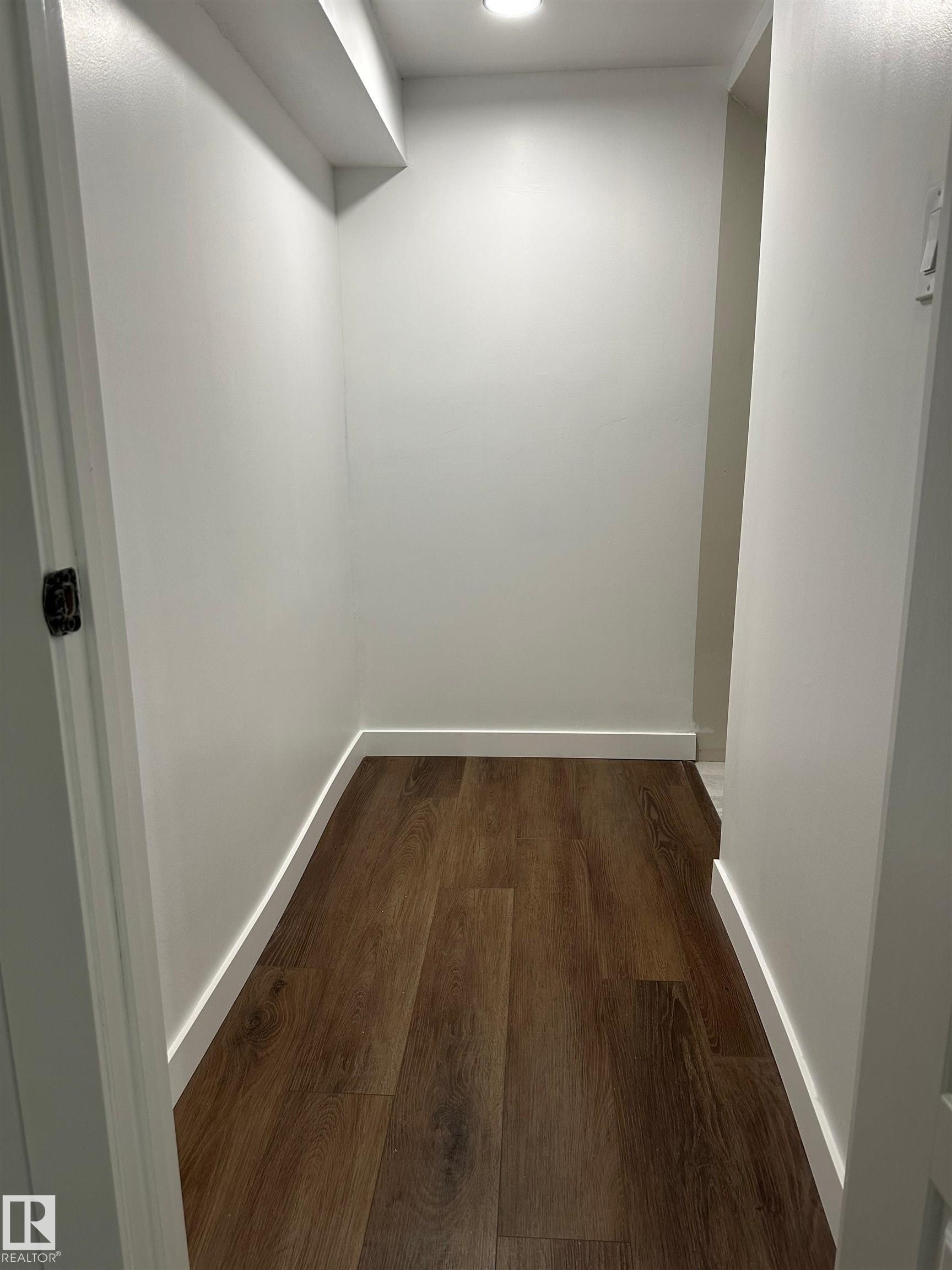 Recessed ceiling lighting, wood-finish flooring, white wall paint, and white baseboards - 104 Meadowview Way, Leduc, AB - Indoor Photo Showing Other Room