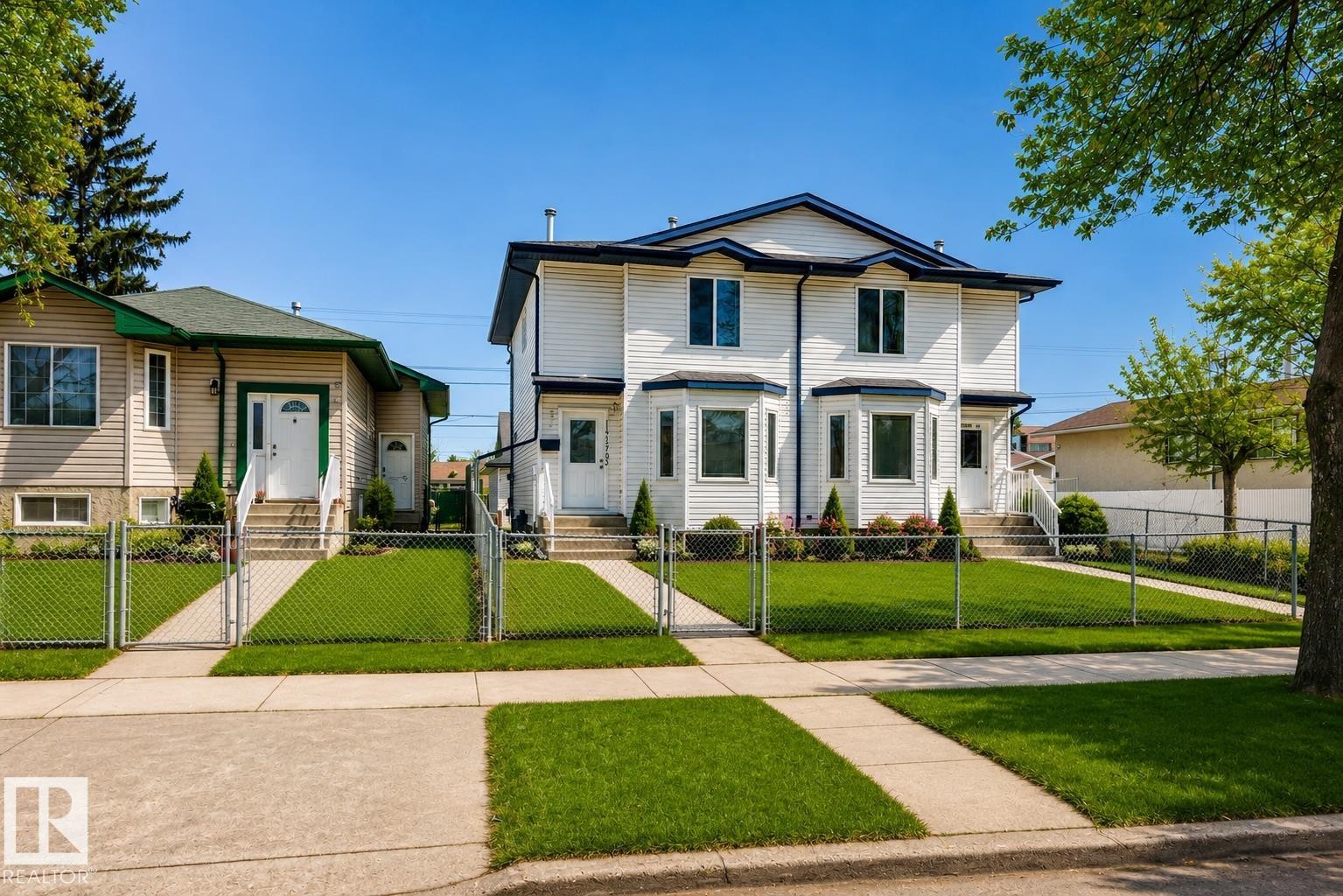 Virtually enhanced image of two-story duplex with white siding, bay windows, and a blue trim roof - 11727 83 Street Nw, Edmonton, AB - Outdoor With Facade