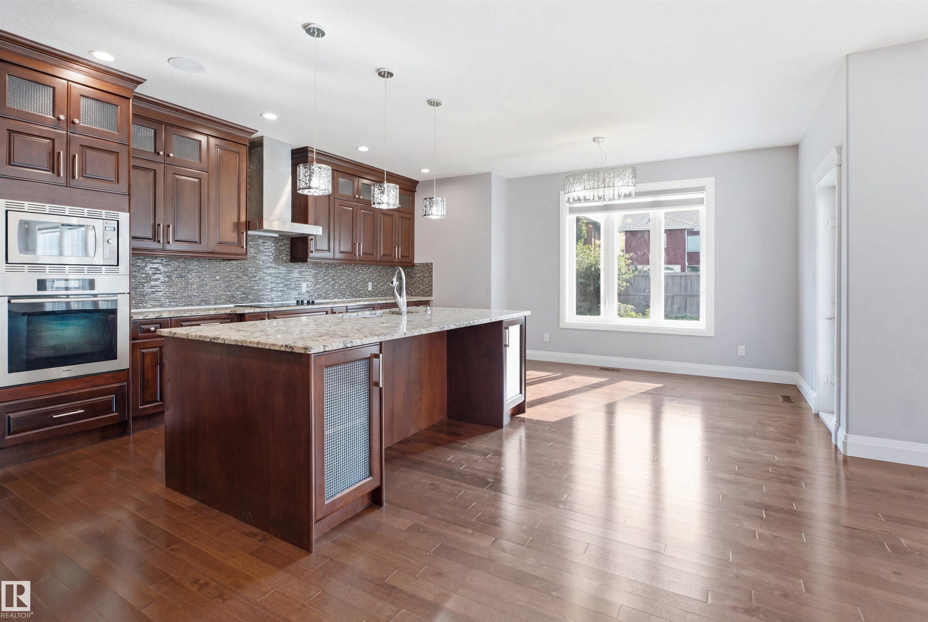 Kitchen with wood-finish flooring, dark wood cabinetry, granite countertops, and stainless steel appliances - 427 Windermere Road Nw, Edmonton, AB - Indoor Photo Showing Kitchen With Upgraded Kitchen
